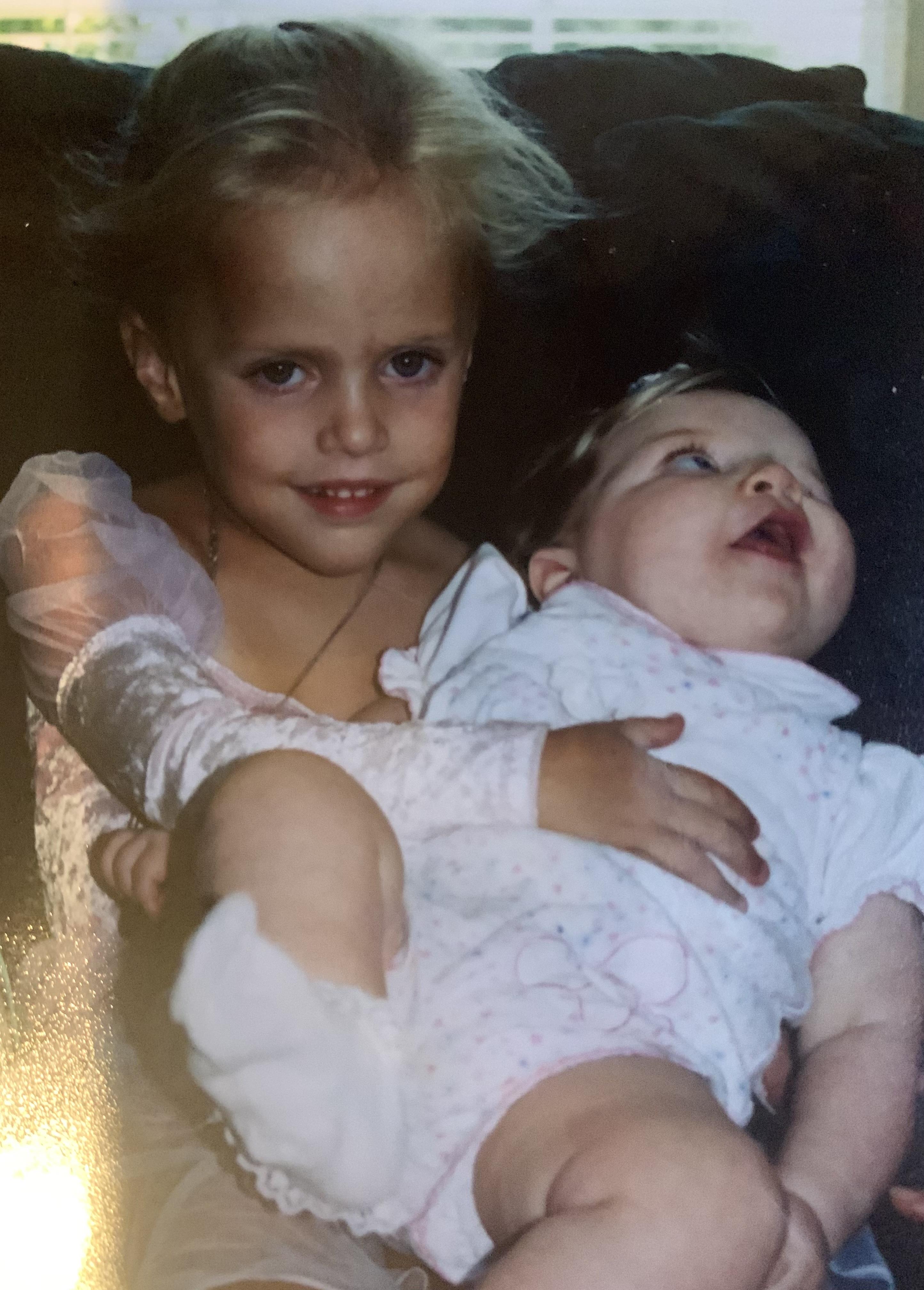A girl holding a baby