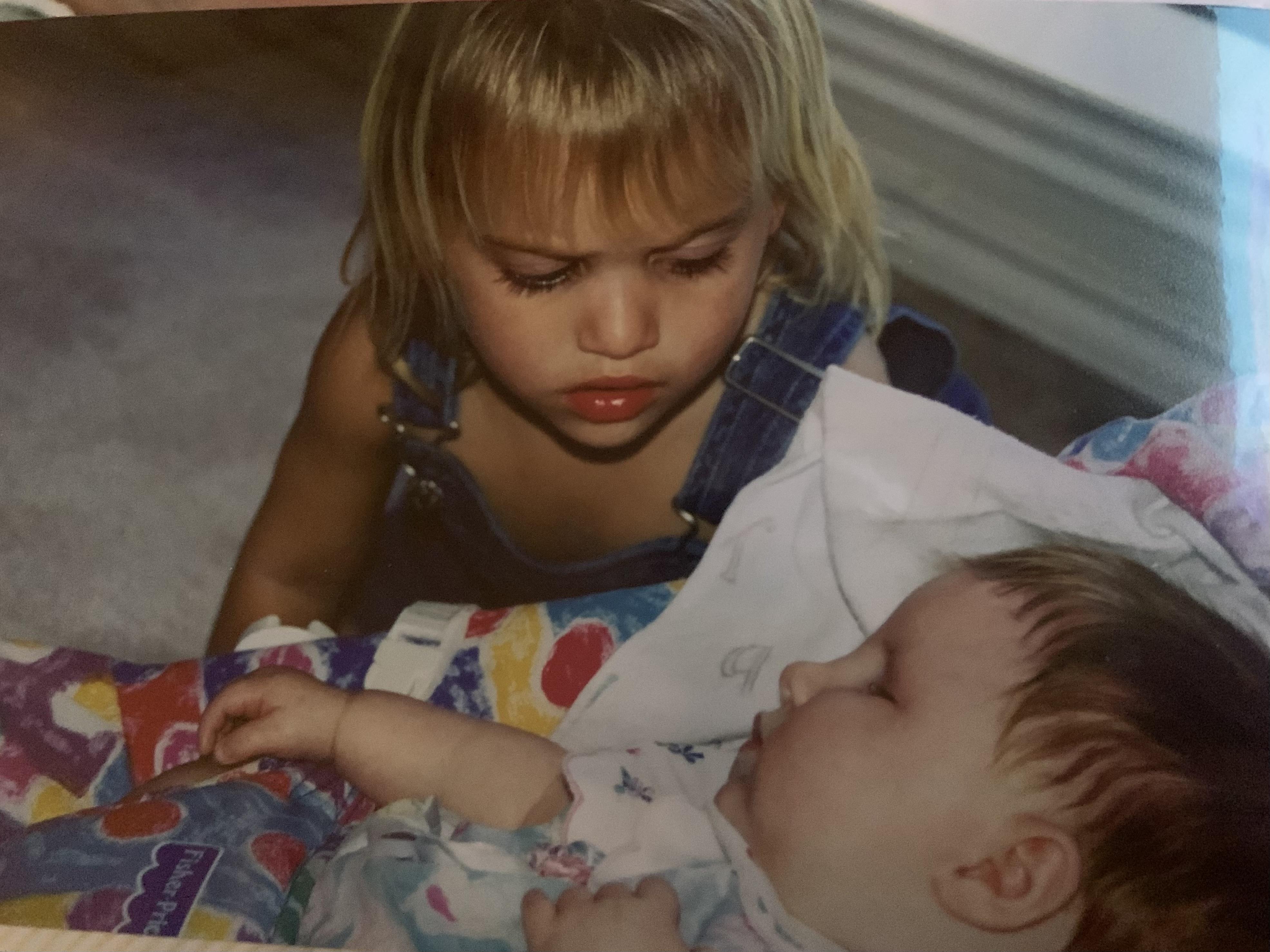 A girl looking at a baby
