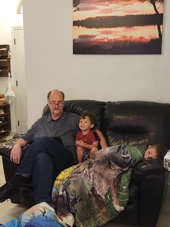 A man and two children sitting on a couch