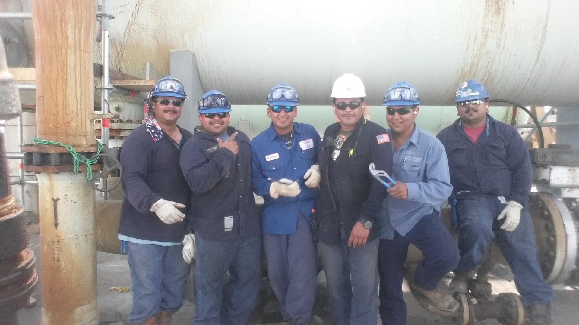 A group of men wearing hard hats and gloves