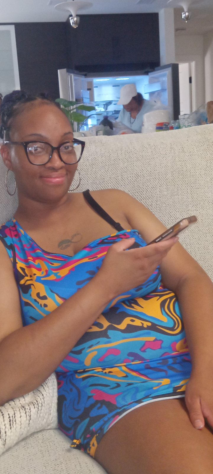 A woman sitting on a couch holding a phone