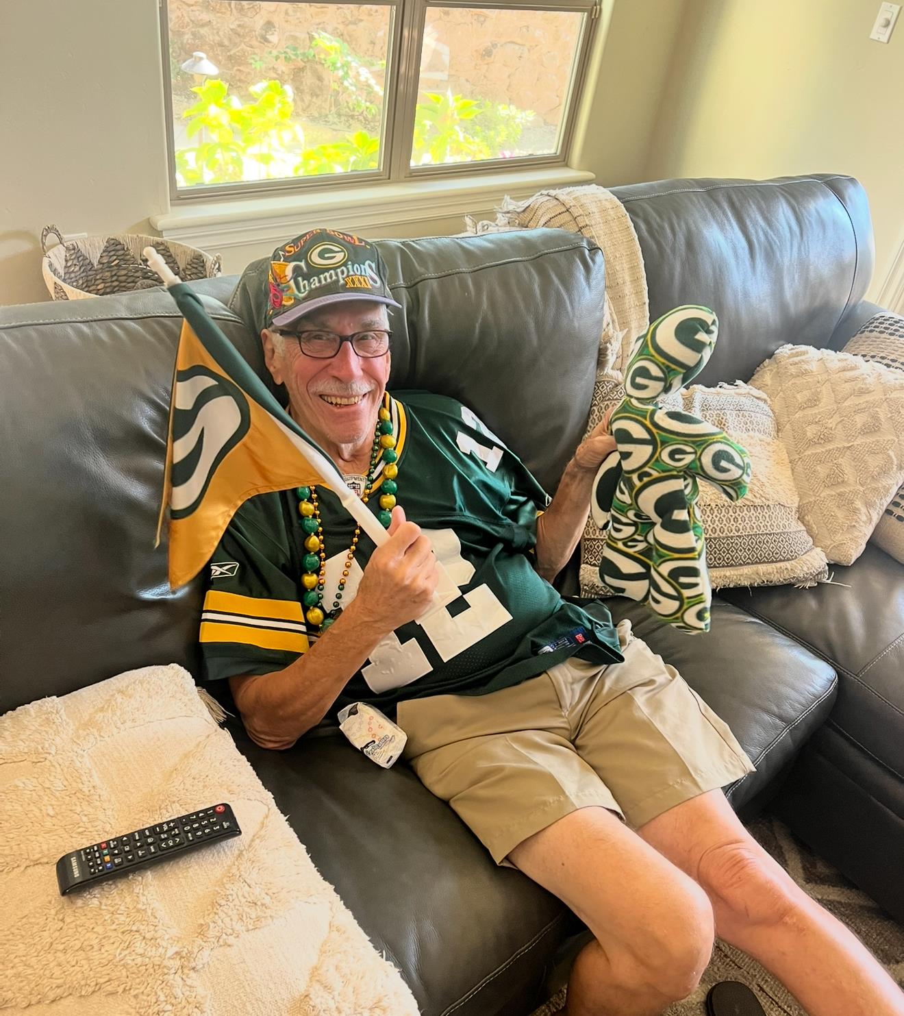A man sitting on a couch holding a flag