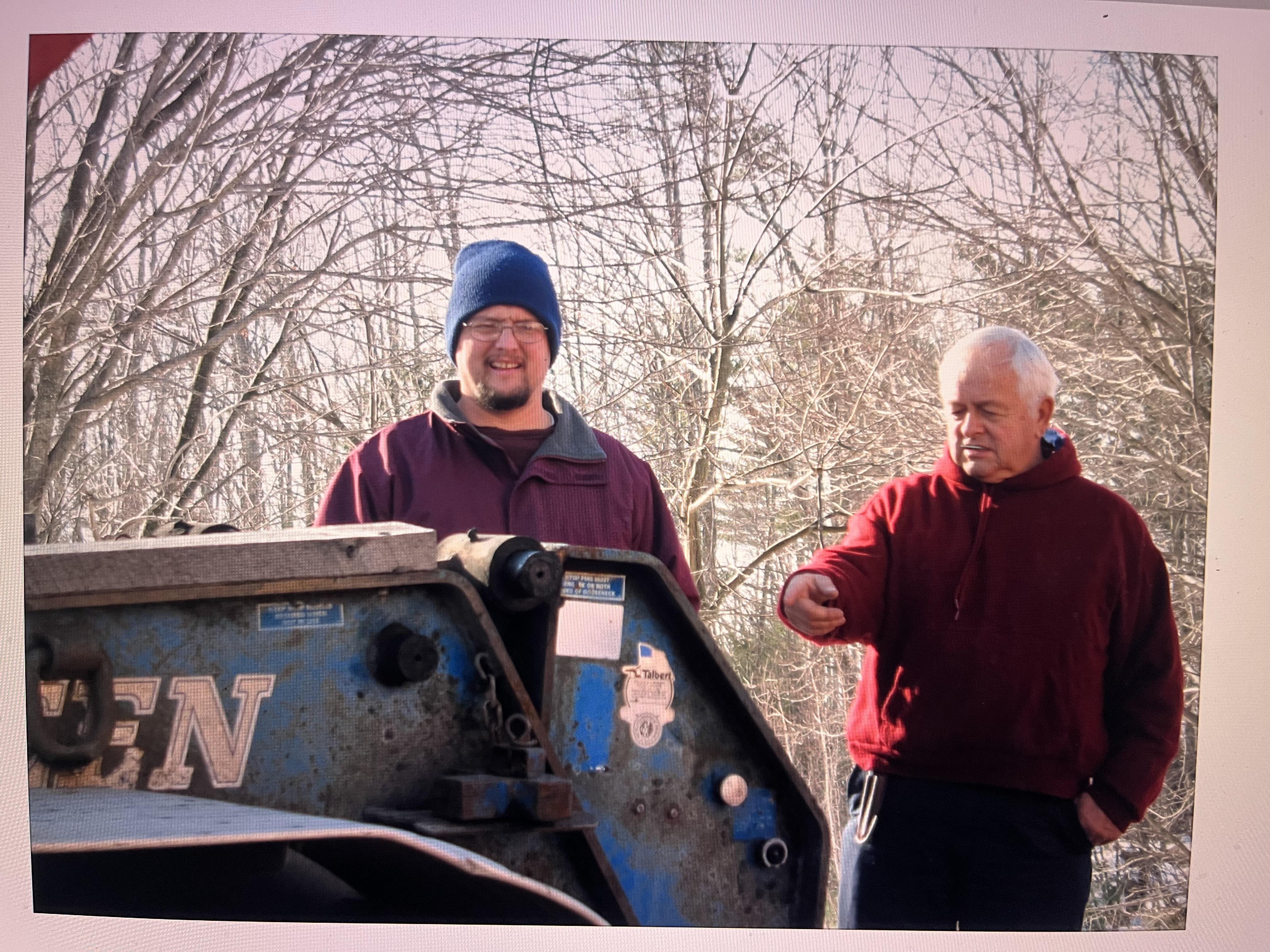 A couple of men standing next to a machine