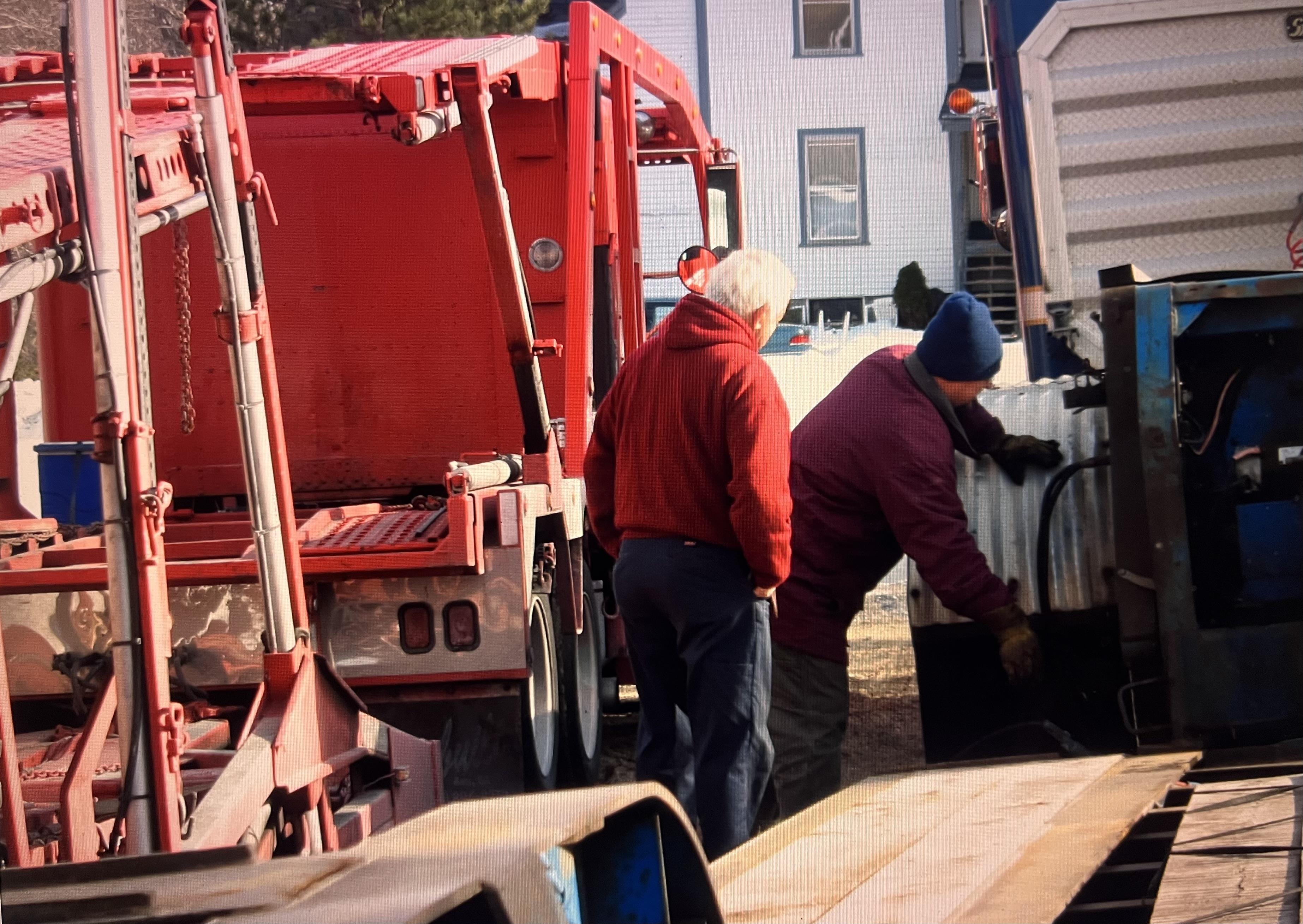 Men loading a truck with a container