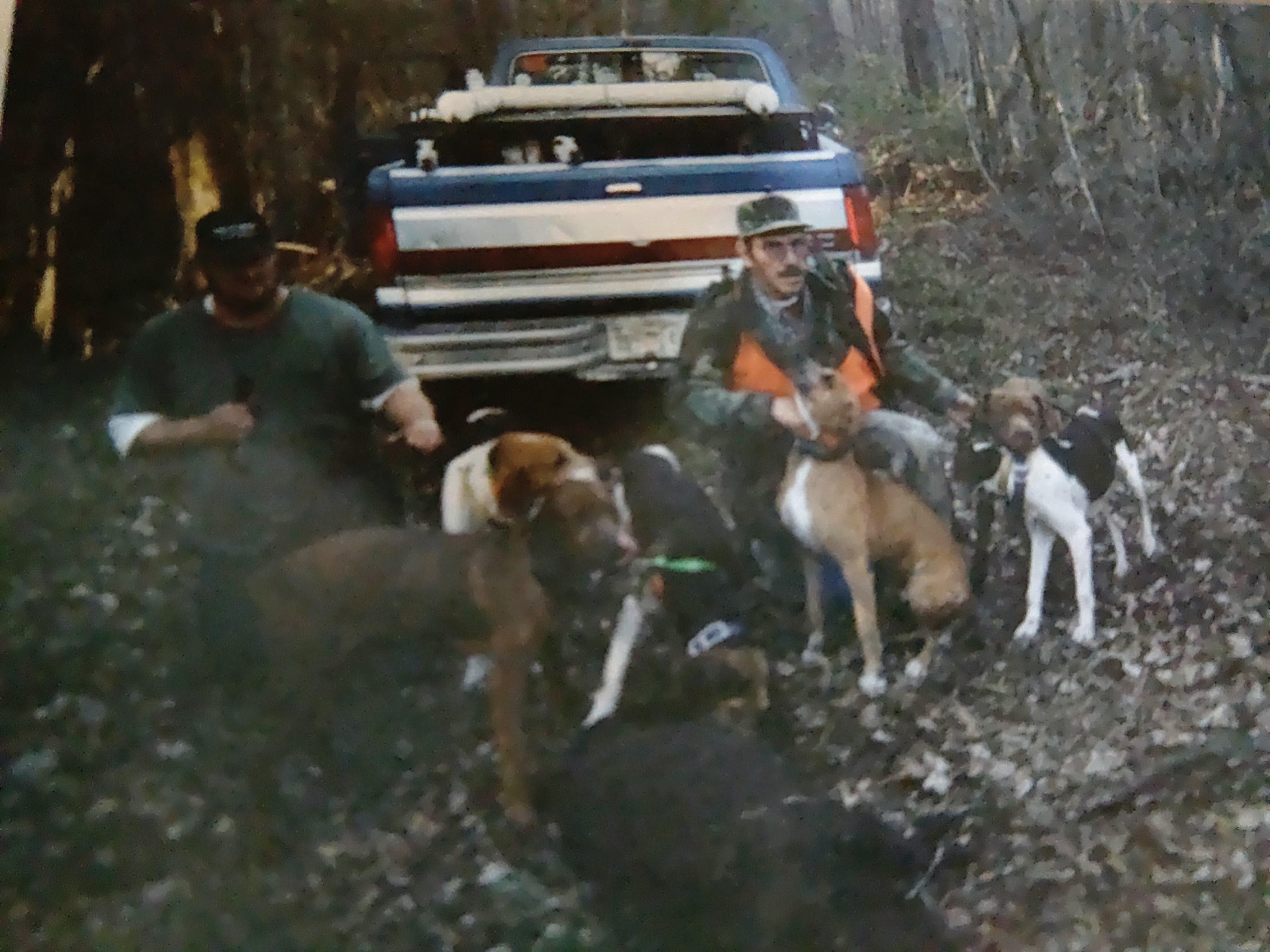 A group of men with dogs in the woods