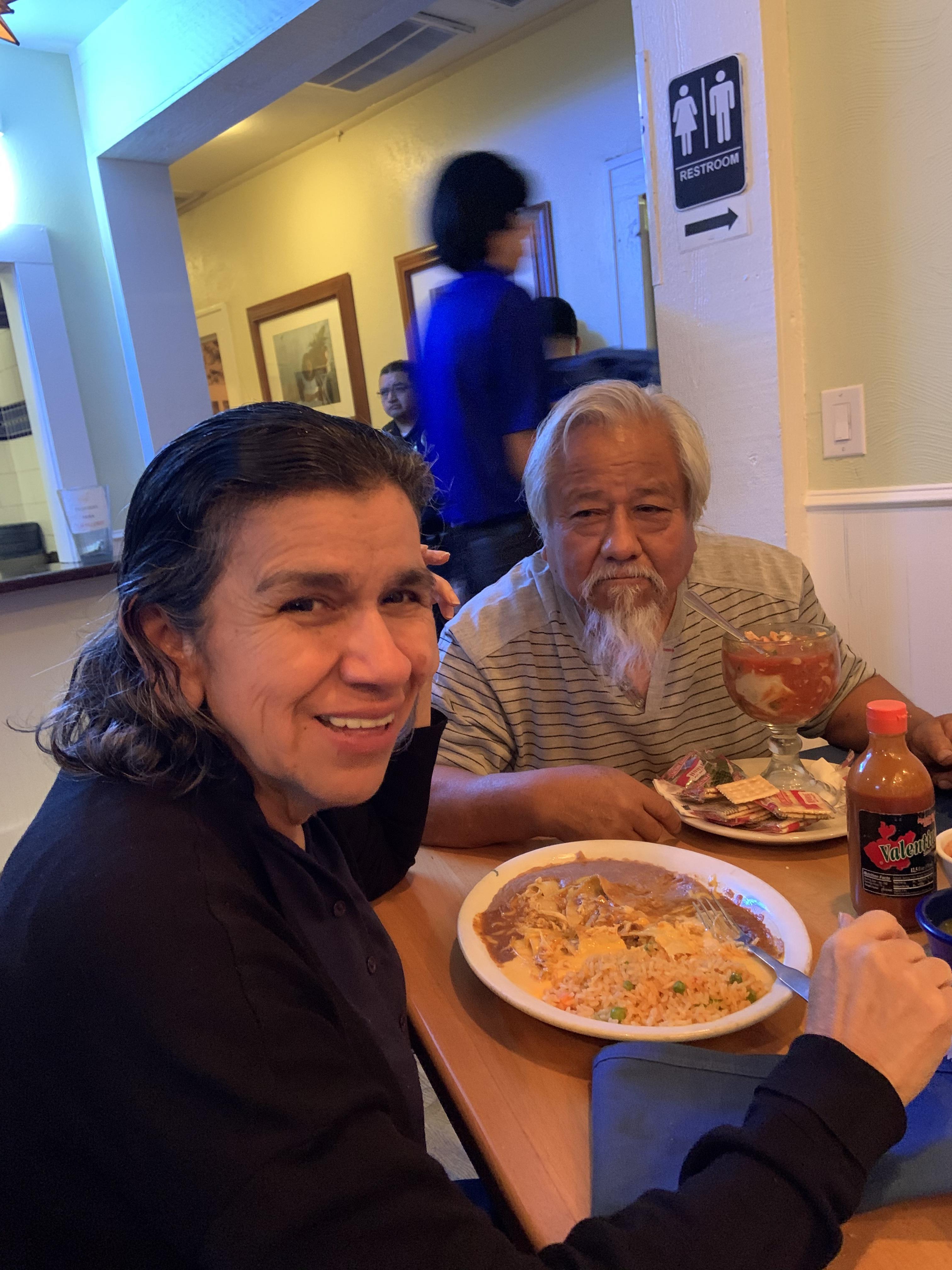 A man and woman sitting at a table with food