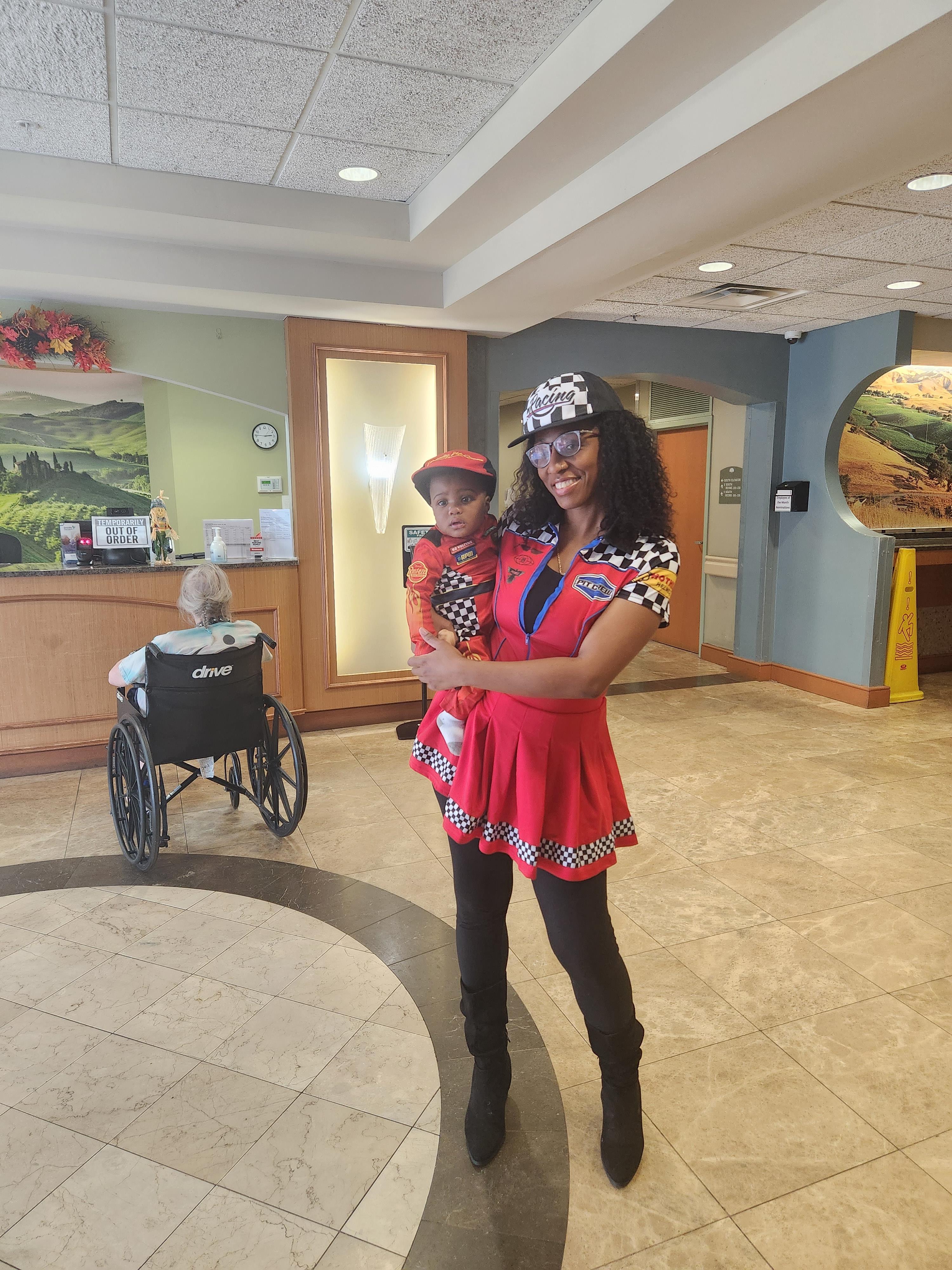 A woman holding a child in a room with a wheelchair
