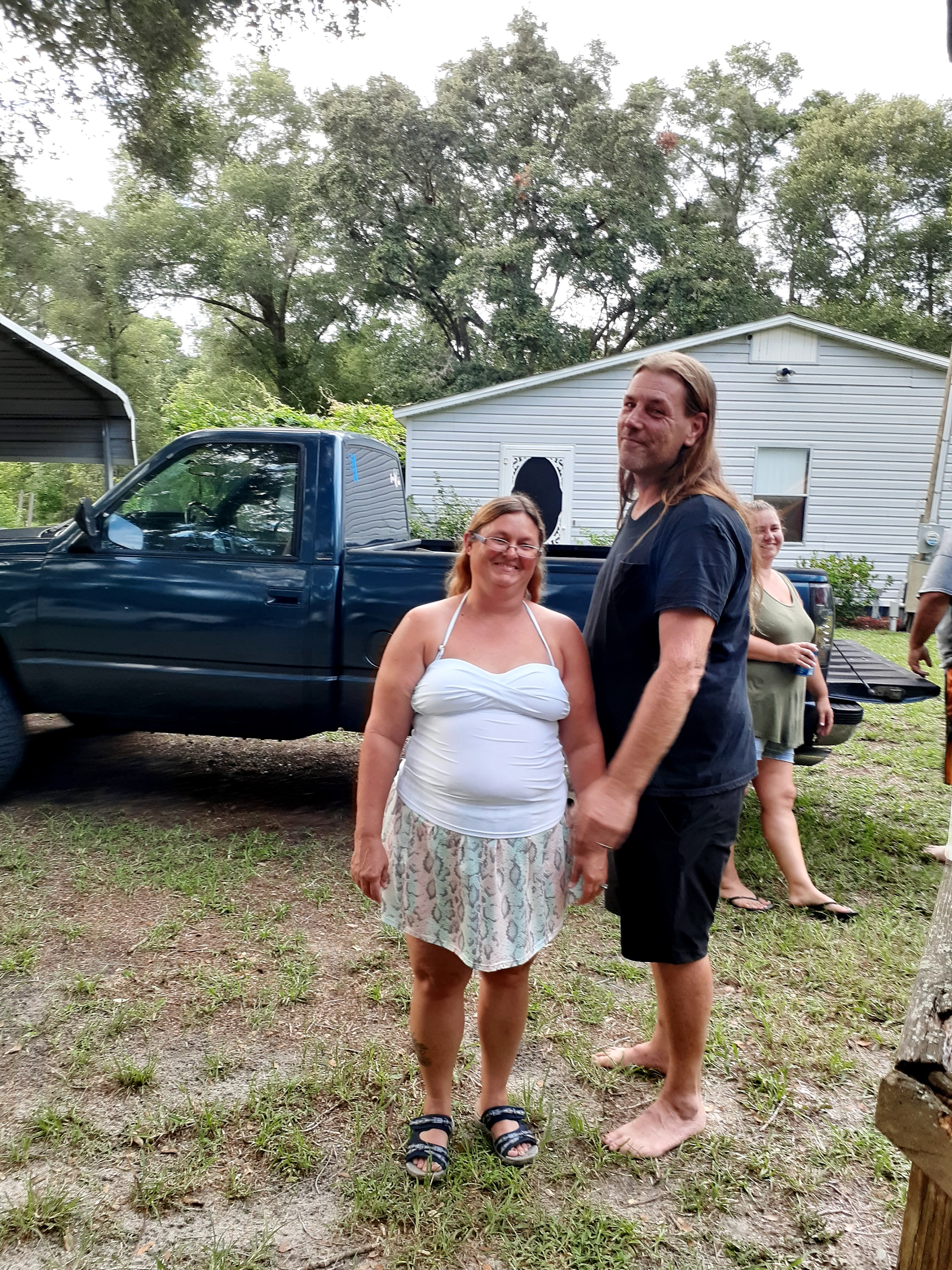 A man and woman standing in front of a truck