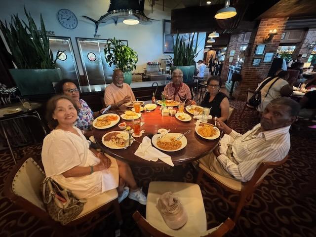 A group of people sitting around a table with food