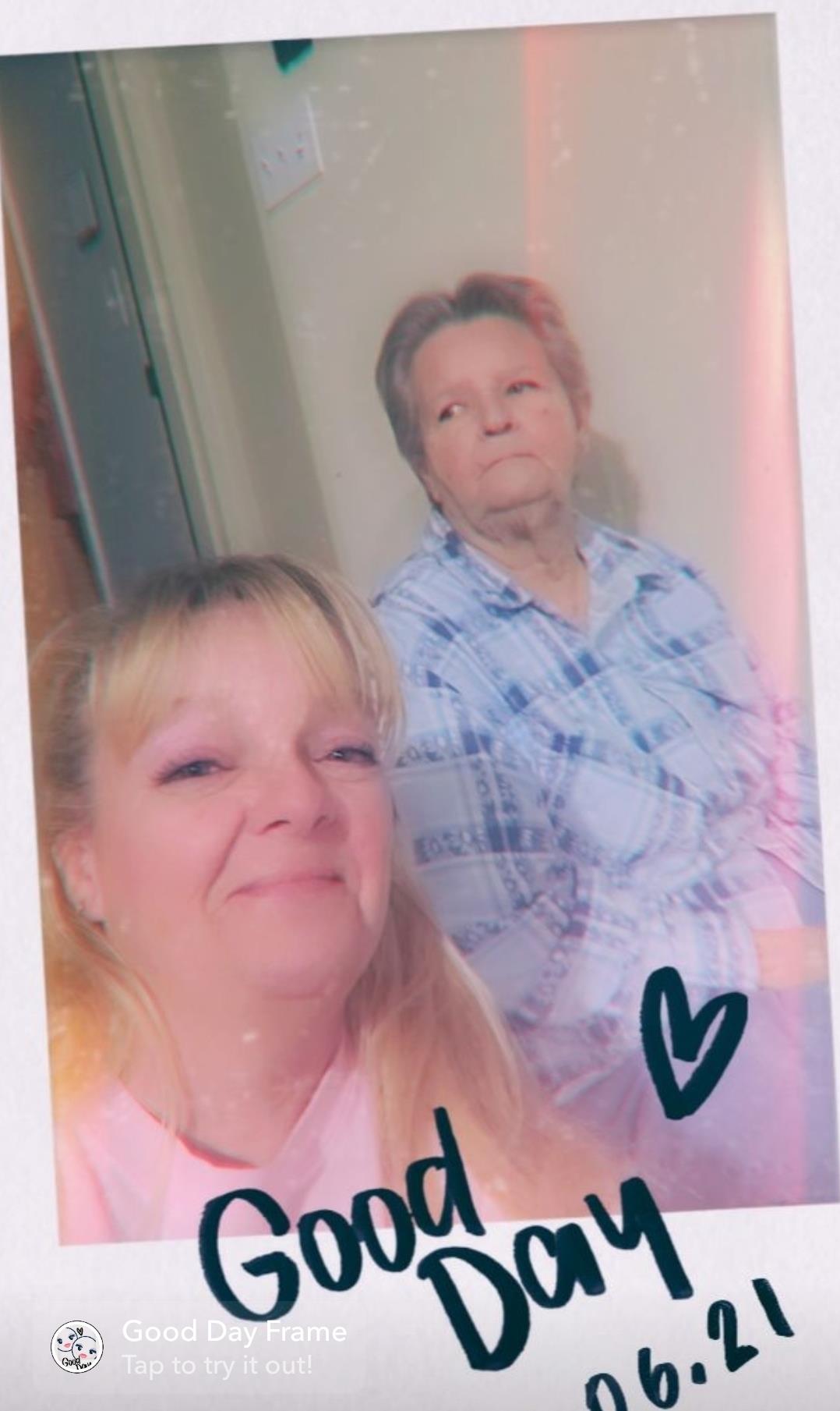 A woman taking a selfie with a woman in a blue shirt