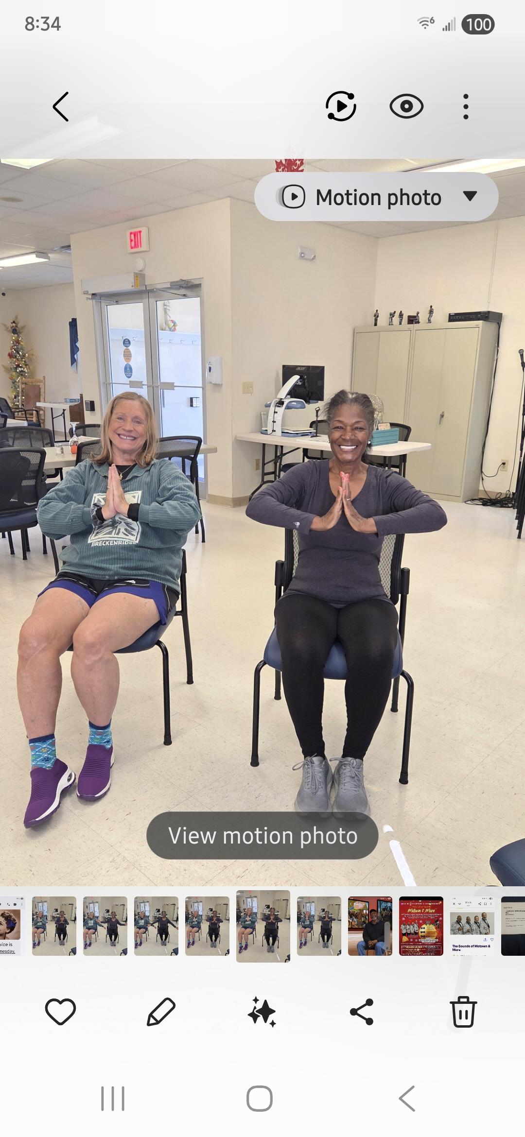 Two women sitting in chairs with their hands together