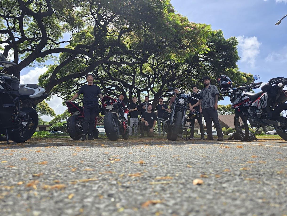 A group of people standing next to motorcycles