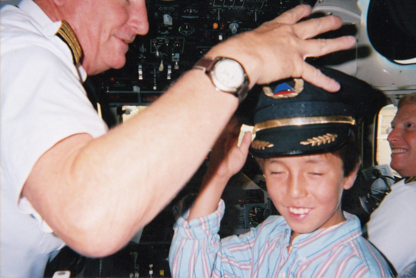 A man putting on a hat on a boy