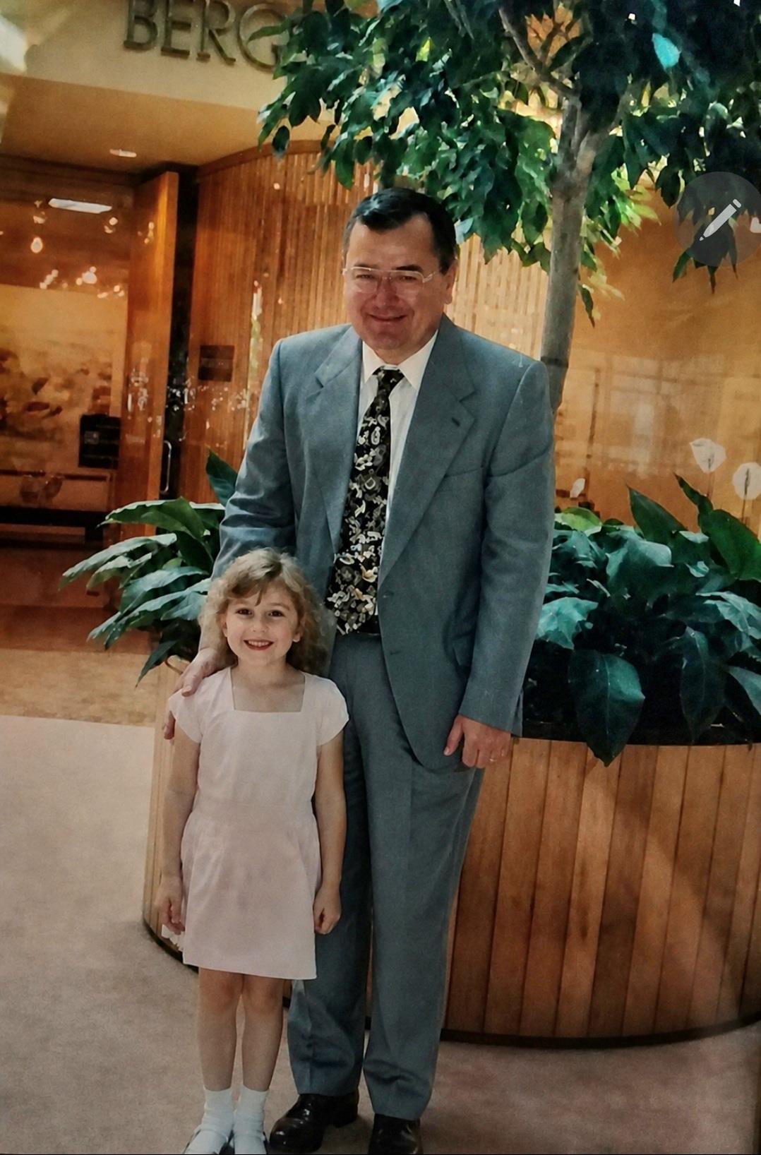 A man in a suit and tie standing next to a girl