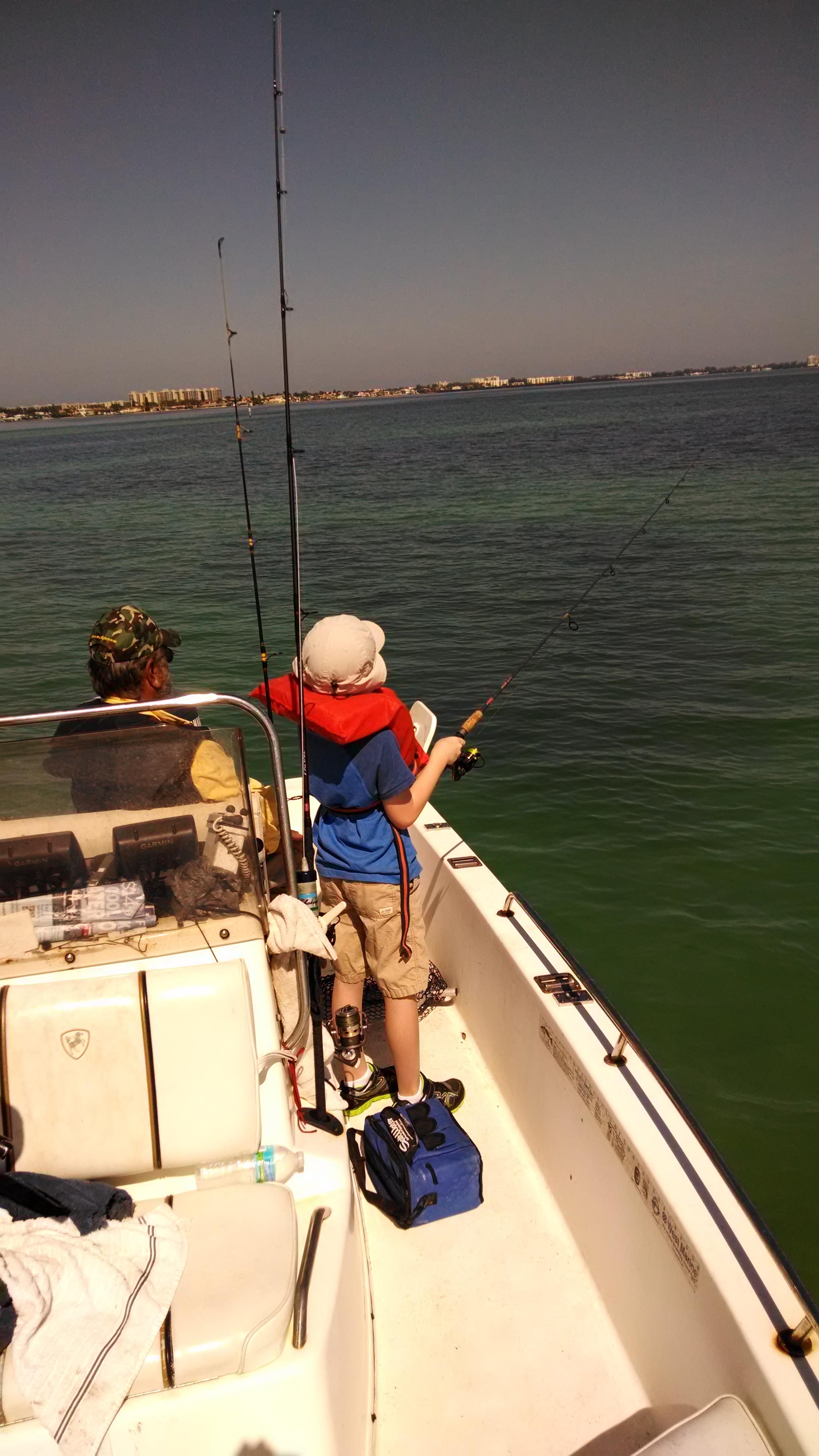 A boy fishing on a boat