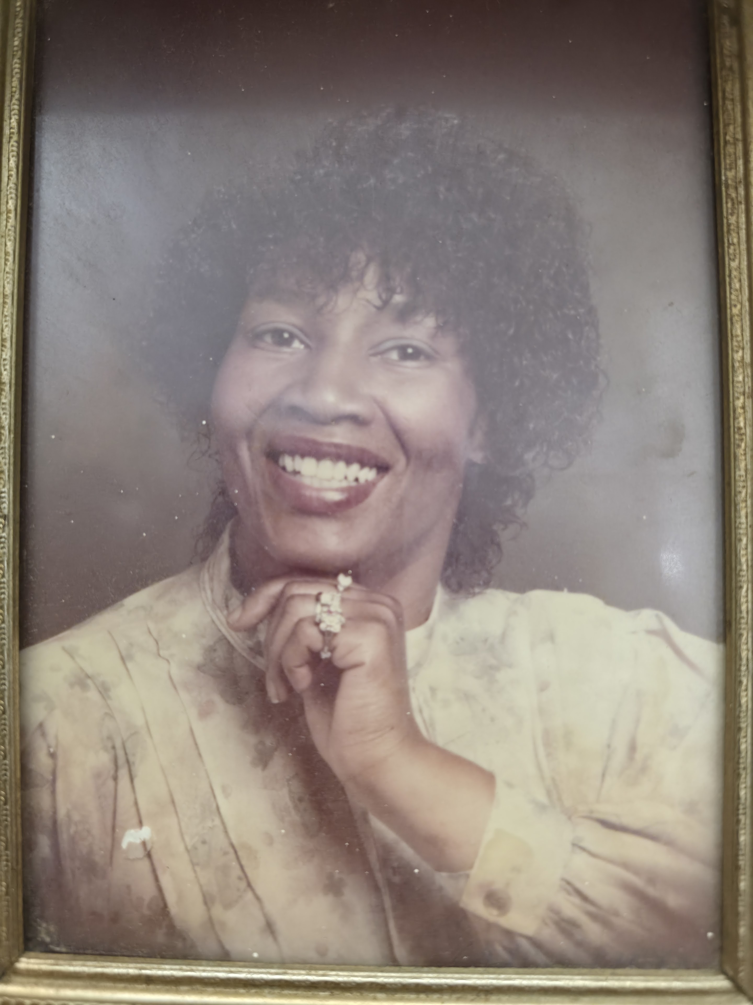 A woman smiling with her hand on her chin