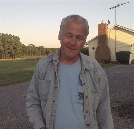 A man standing outside in a driveway