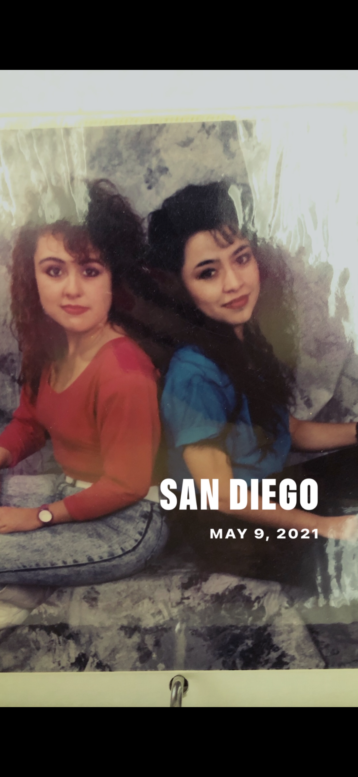 Two women sitting back to back