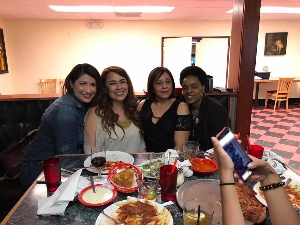 A group of women sitting at a table with food