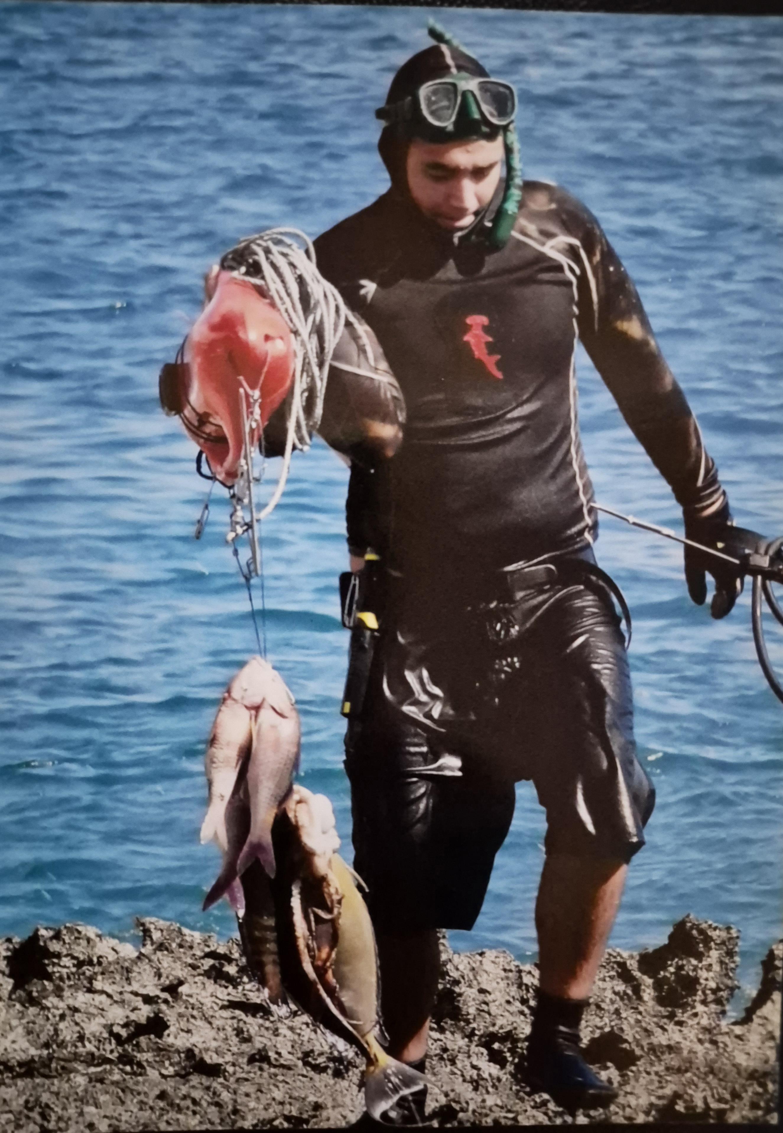 A man holding fish and rope