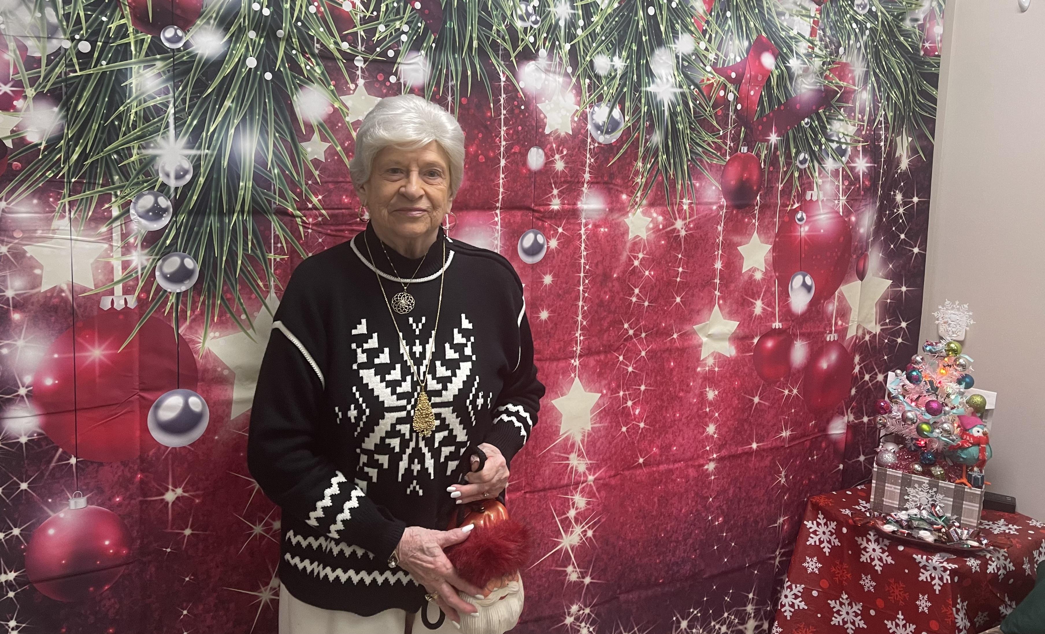 A woman standing in front of a christmas wall