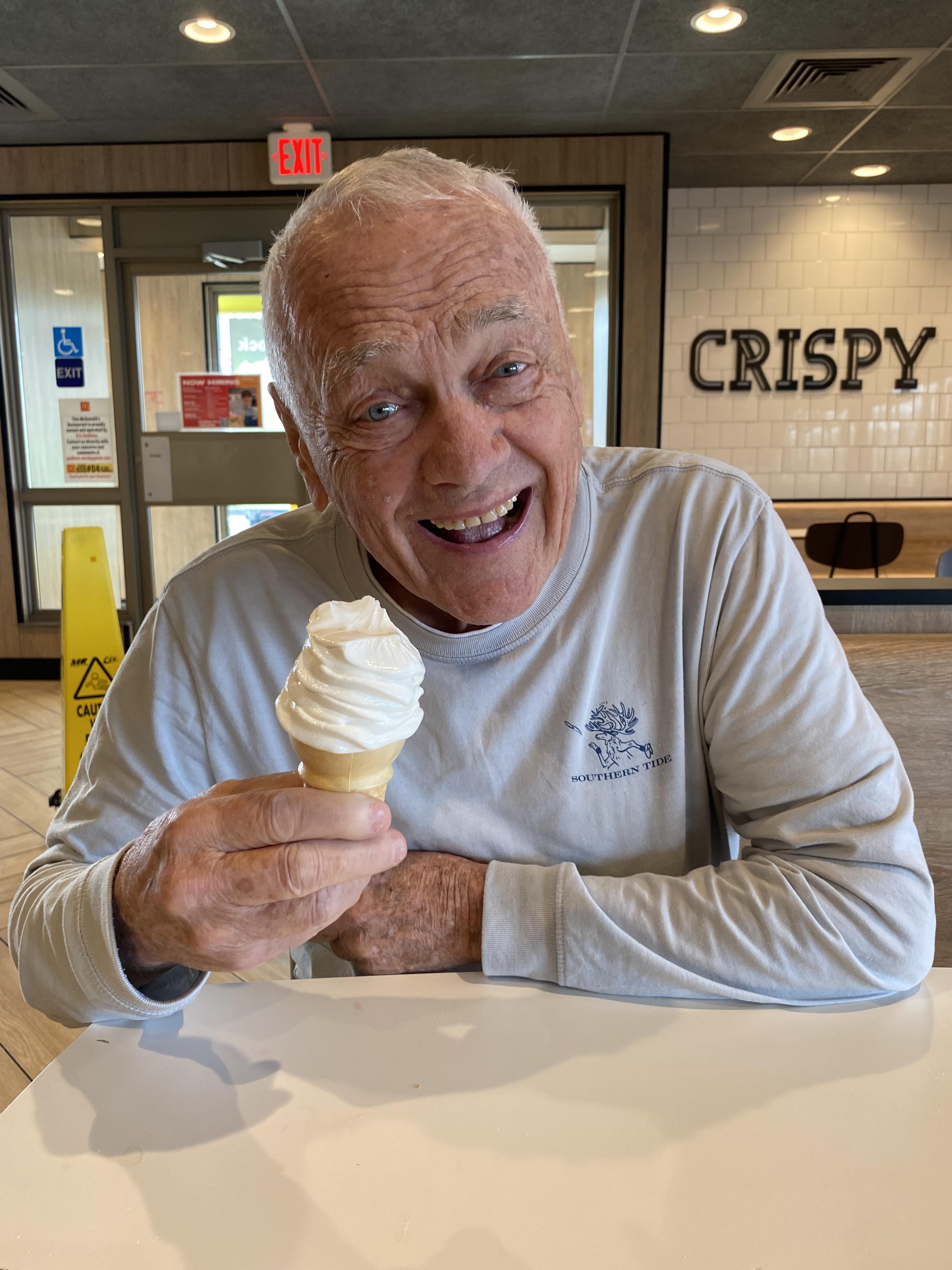 An old man holding an ice cream cone