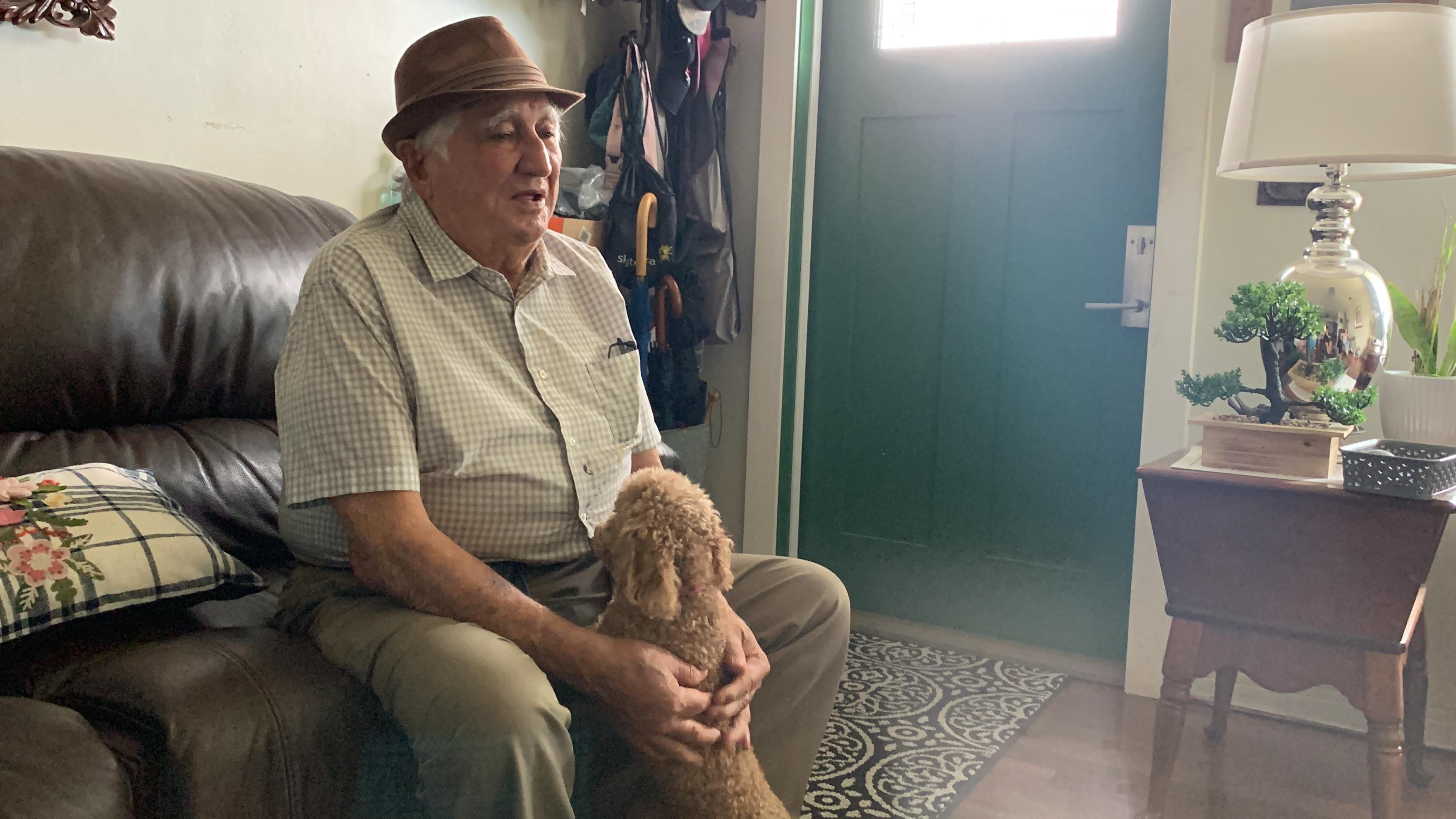 A man sitting on a couch holding a dog