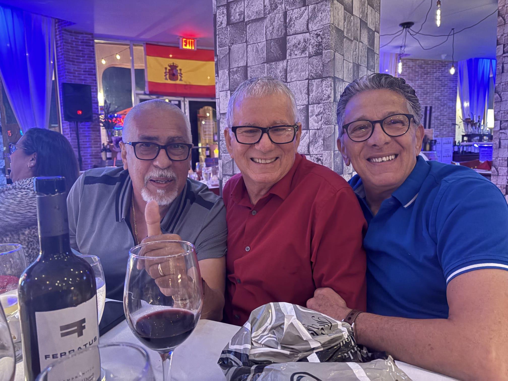A group of men sitting at a table with wine glasses
