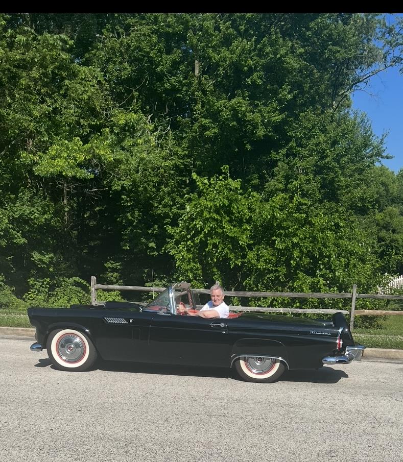 A man driving a convertible car