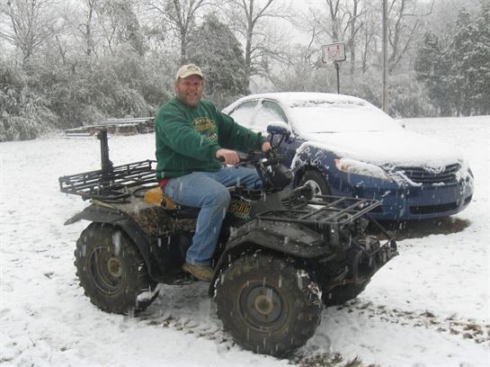 A man on a four wheeler in the snow