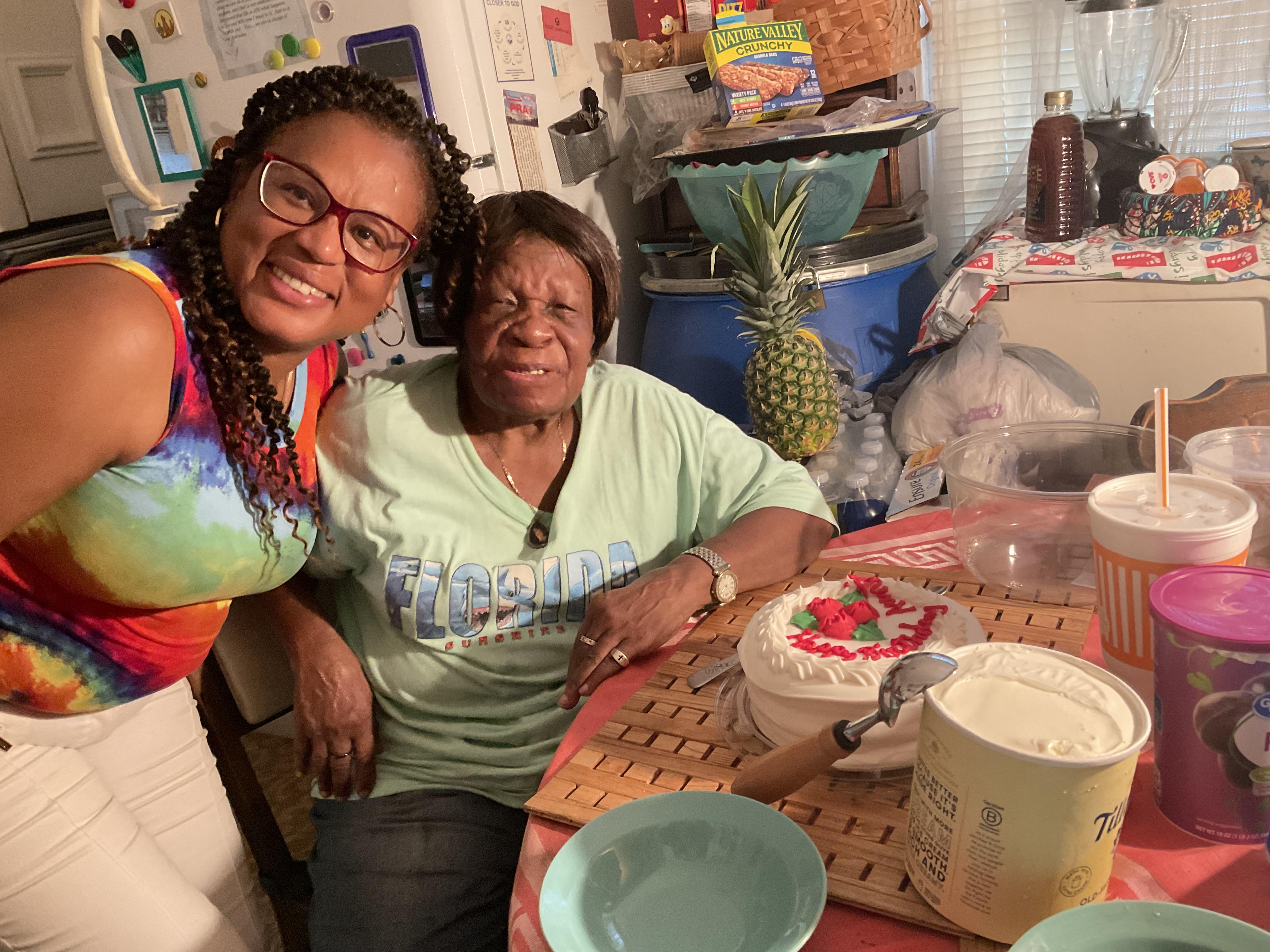 A woman and a woman sitting at a table with food