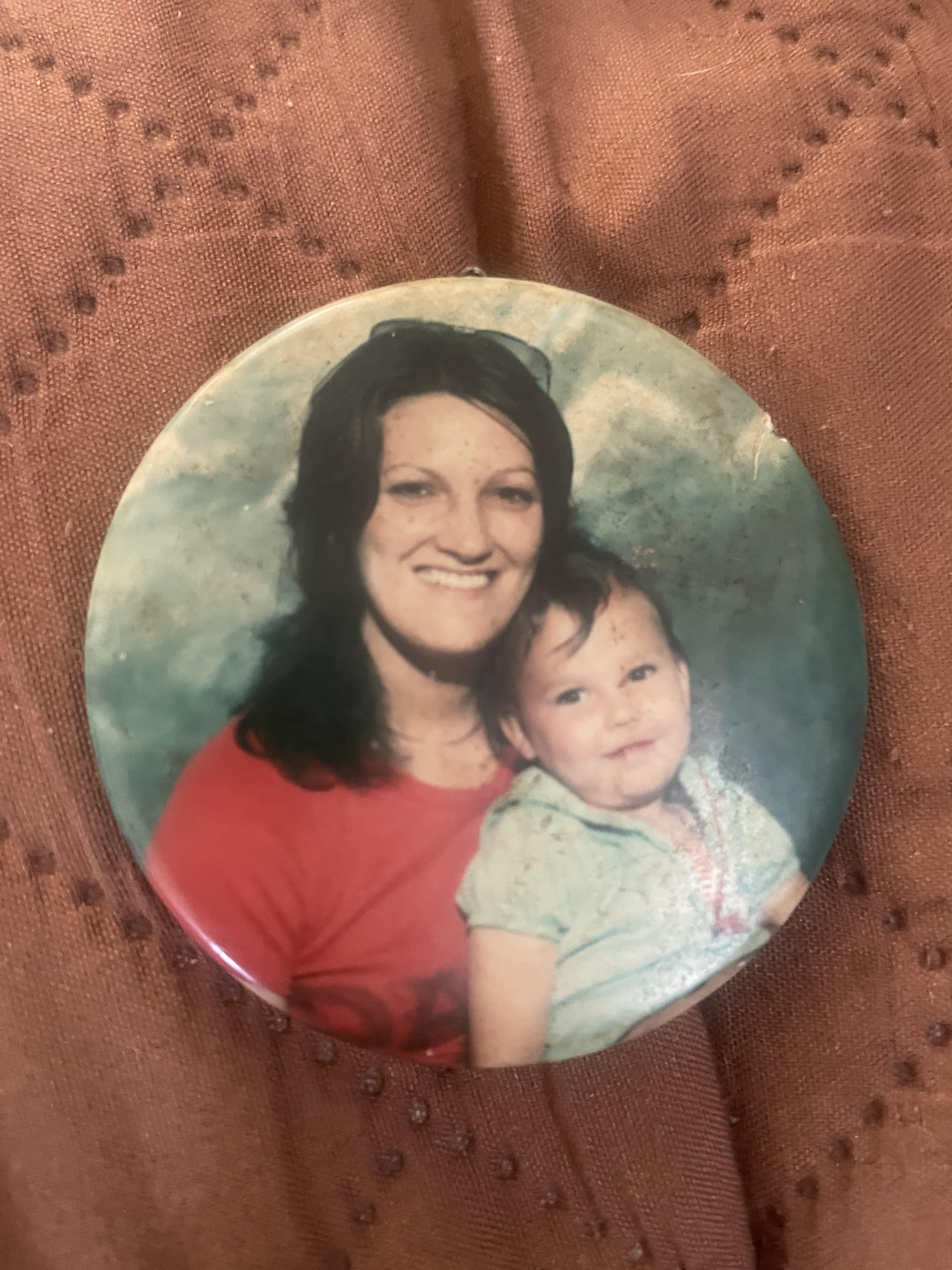 A button with a woman and a child