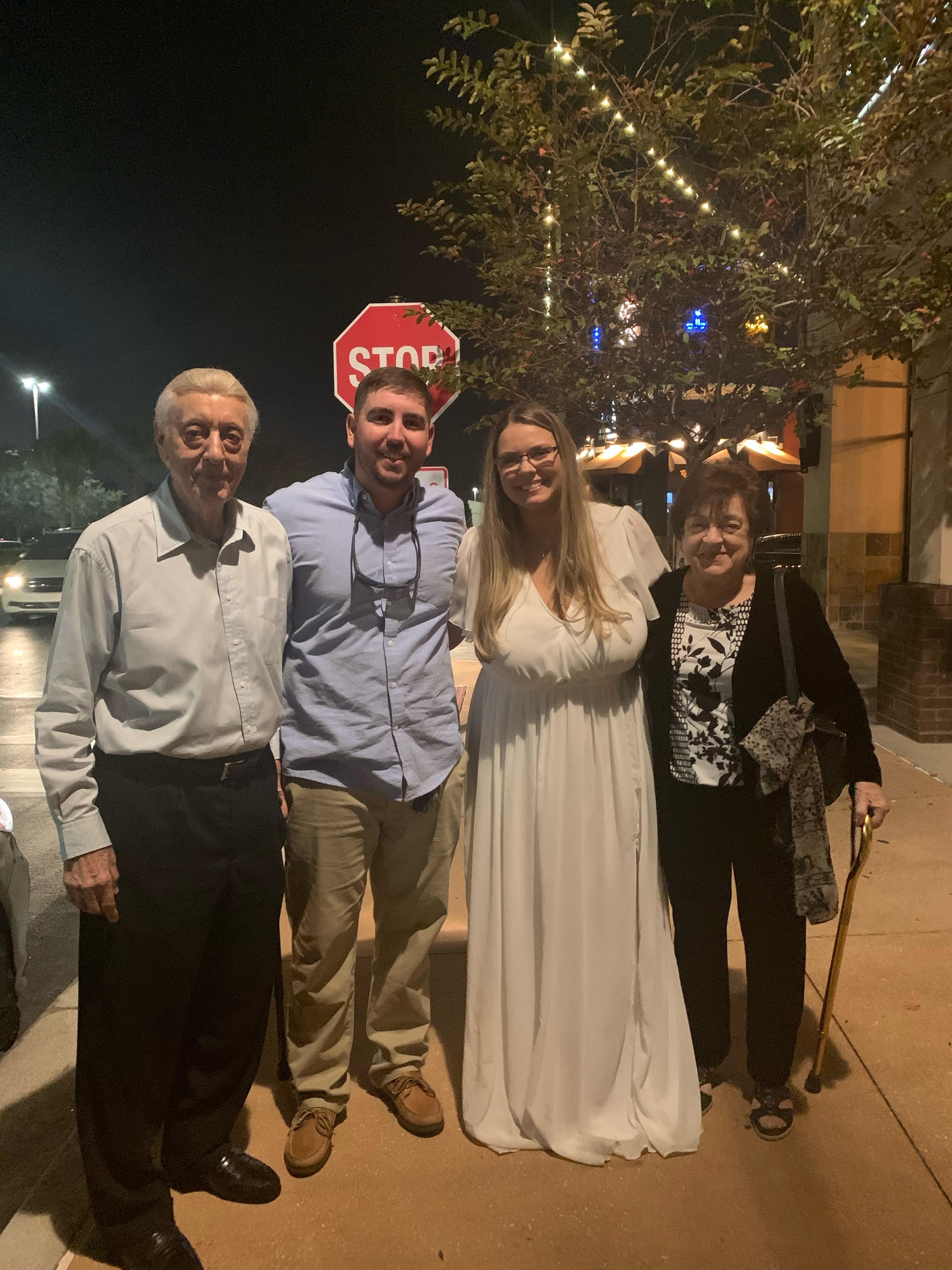 A group of people standing on a sidewalk