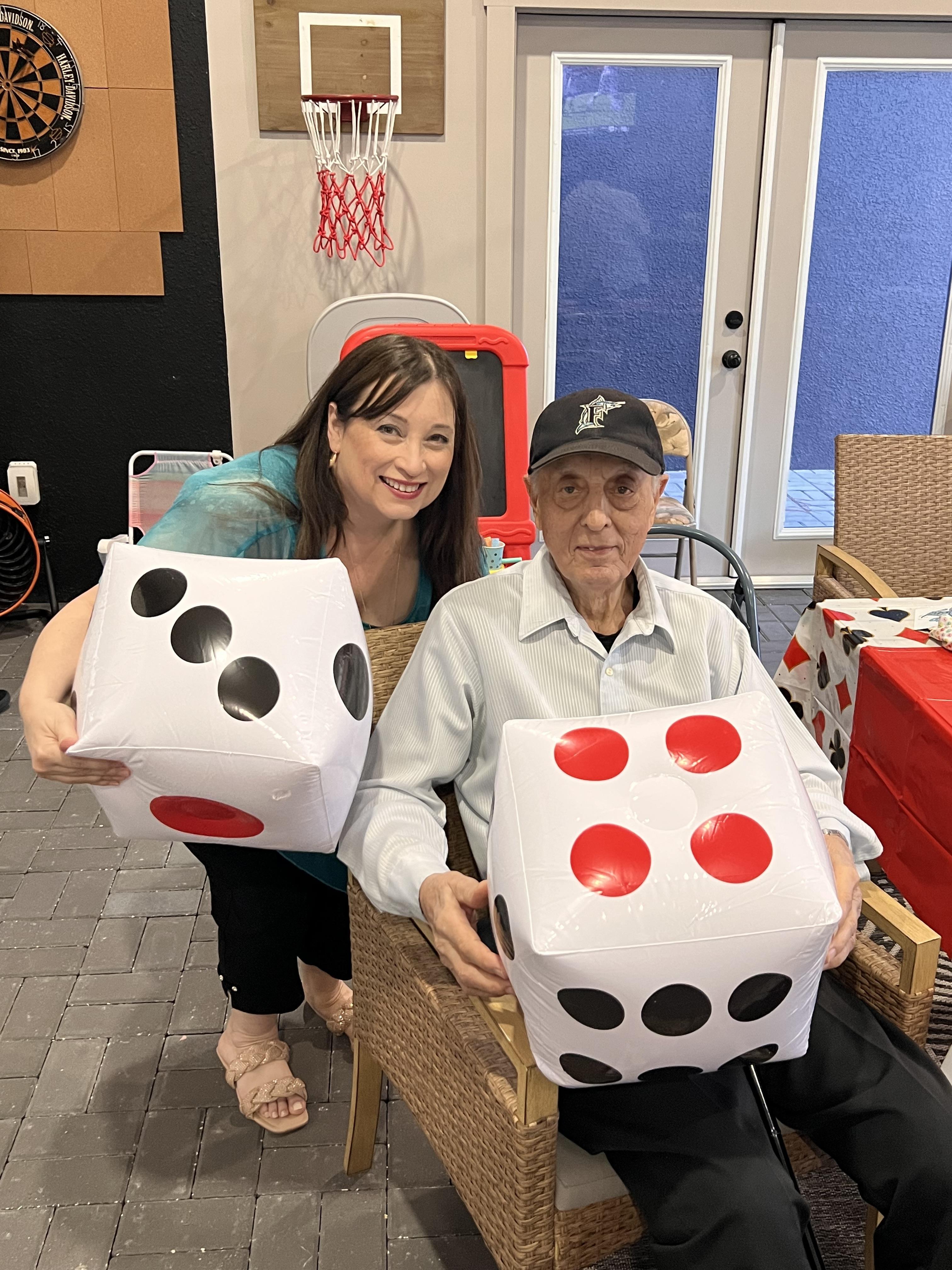 A man and woman holding large dice