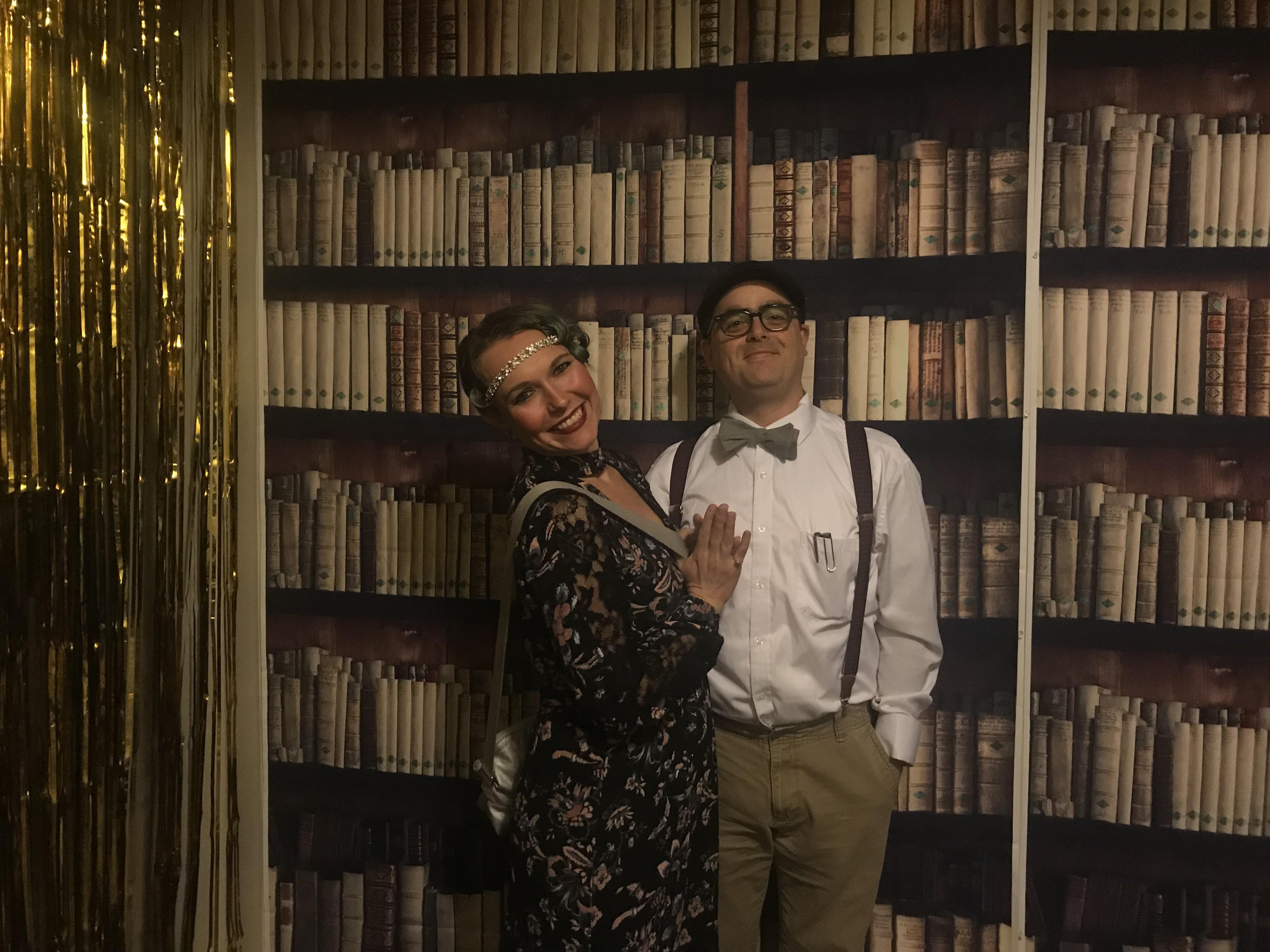 A man and woman standing in front of a bookcase