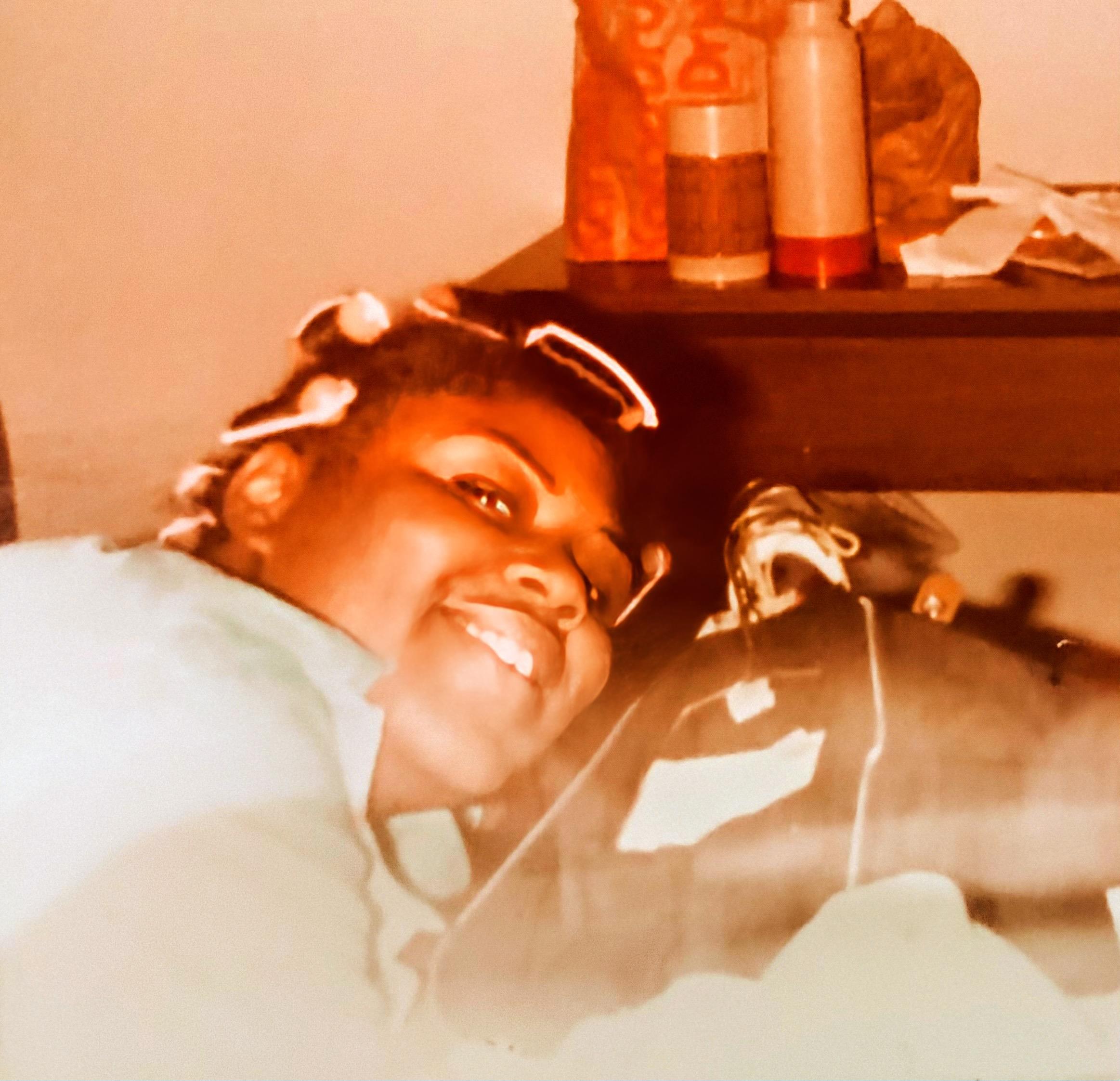 A woman smiling with hair rollers