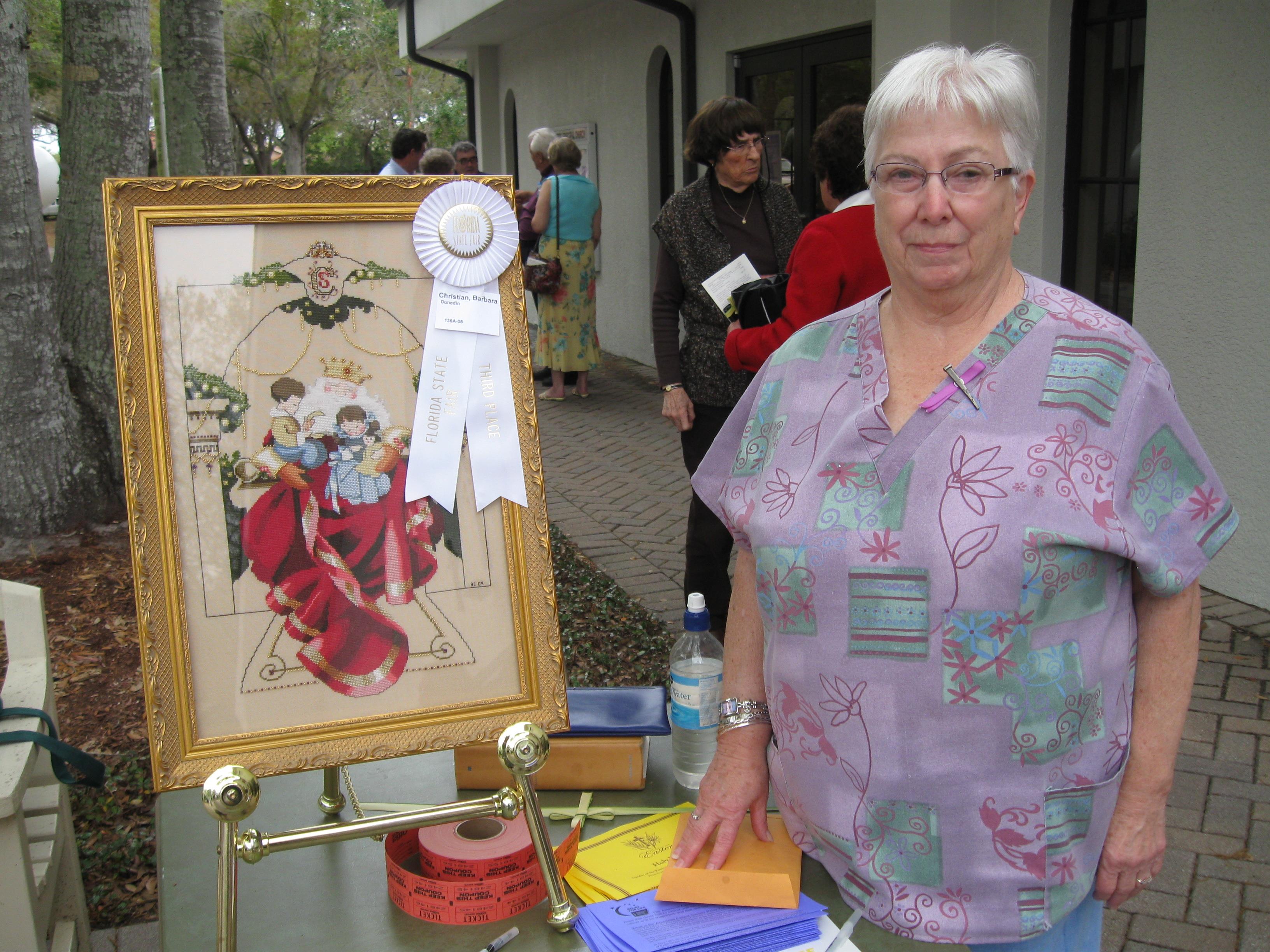 A woman standing next to a framed painting