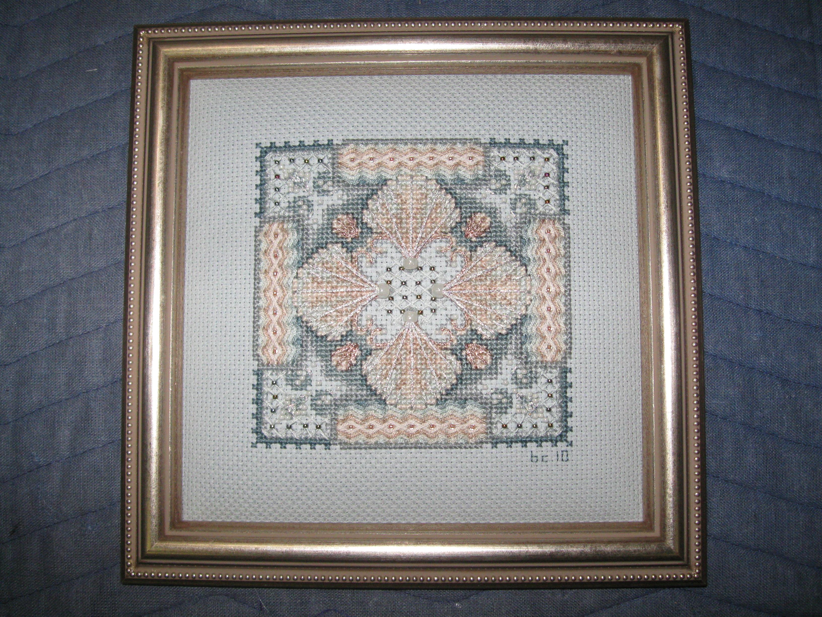 A cross stitched picture in a frame