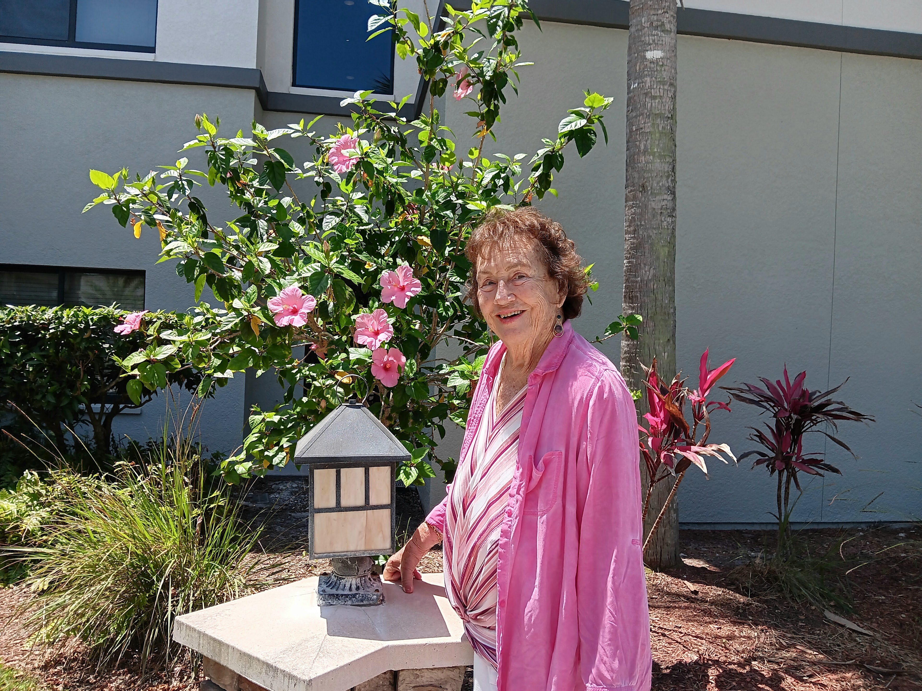 A woman standing next to a small lamp