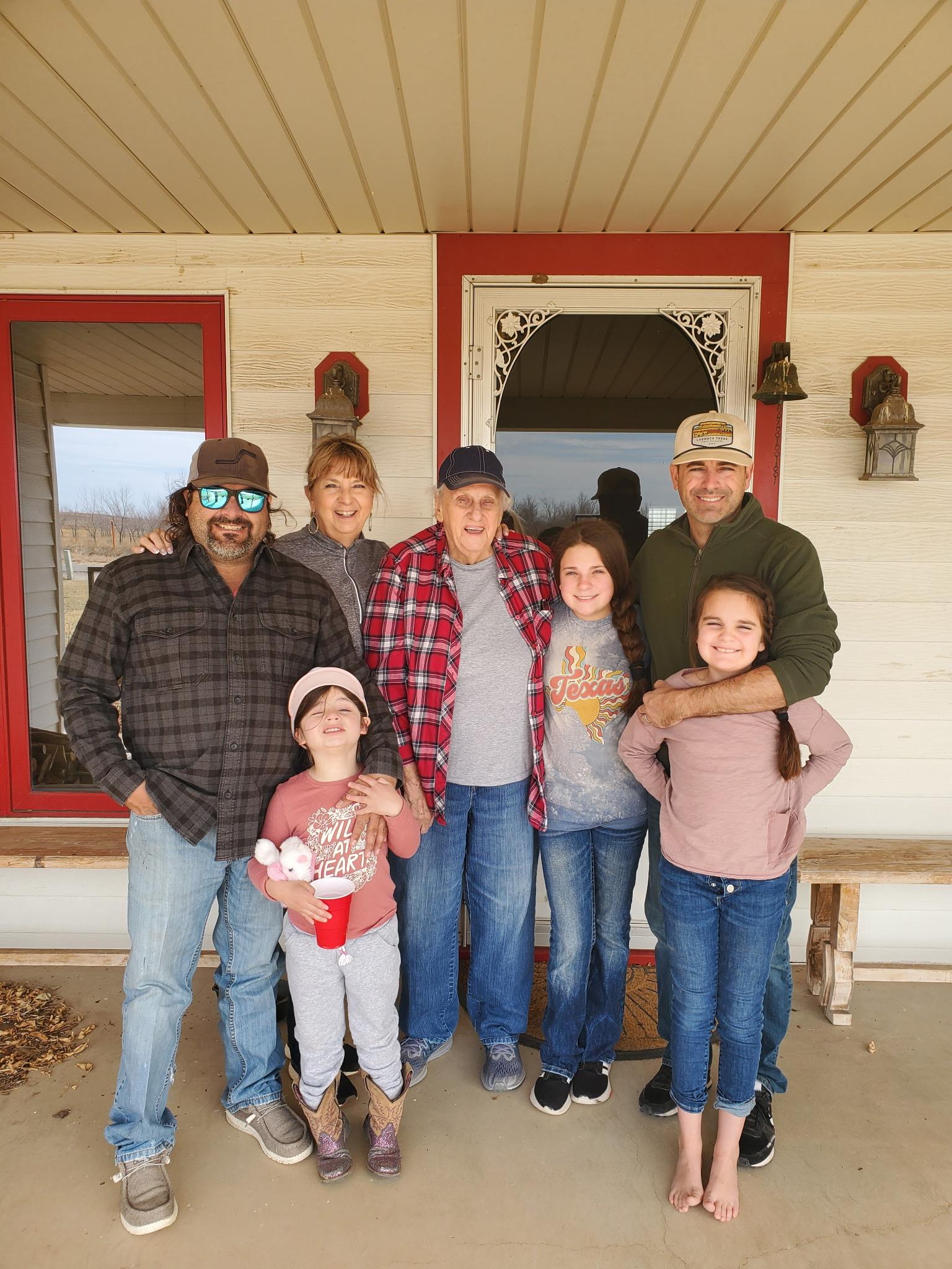 A group of people standing together outside a house