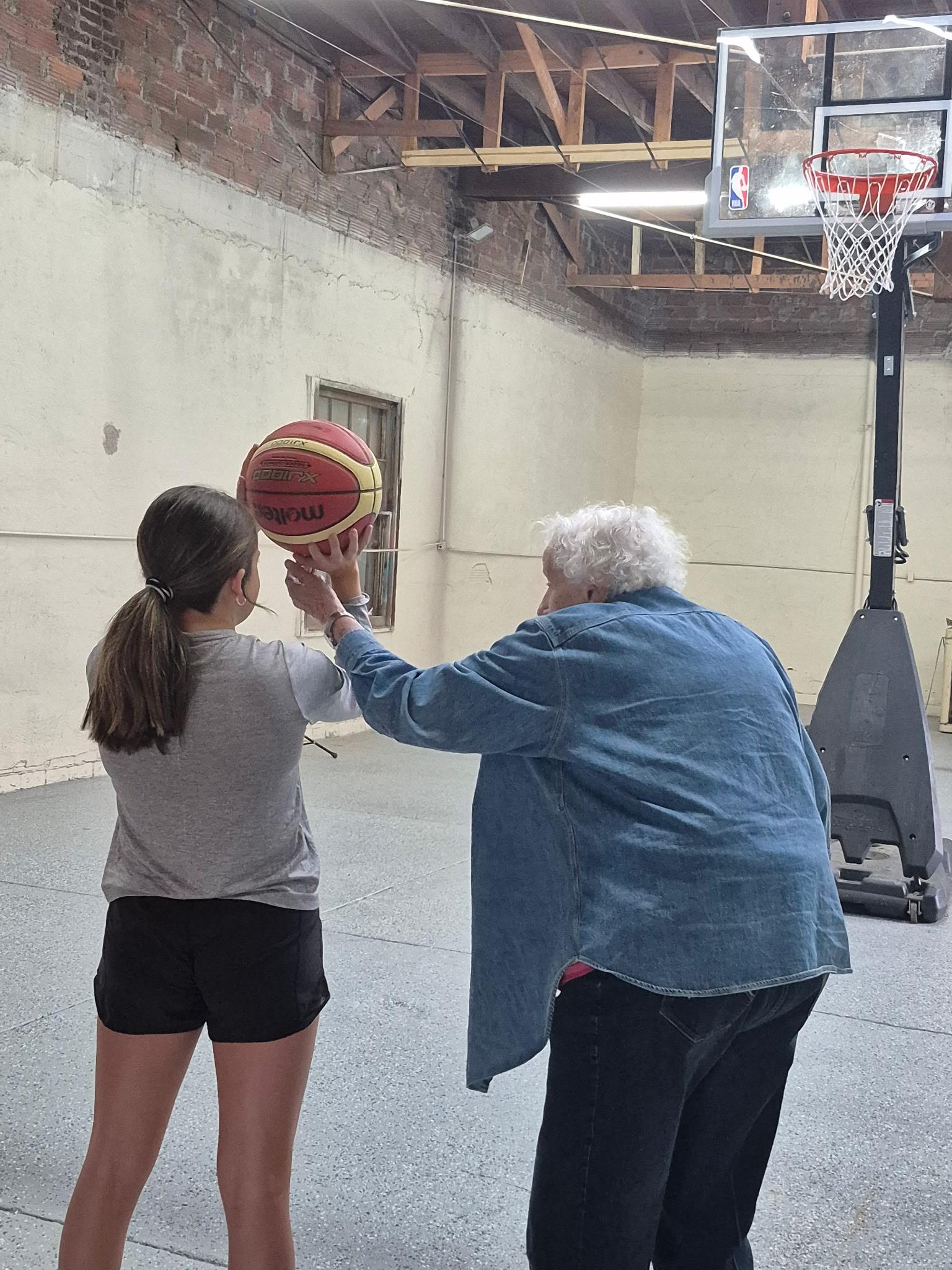 An older woman holding a basketball