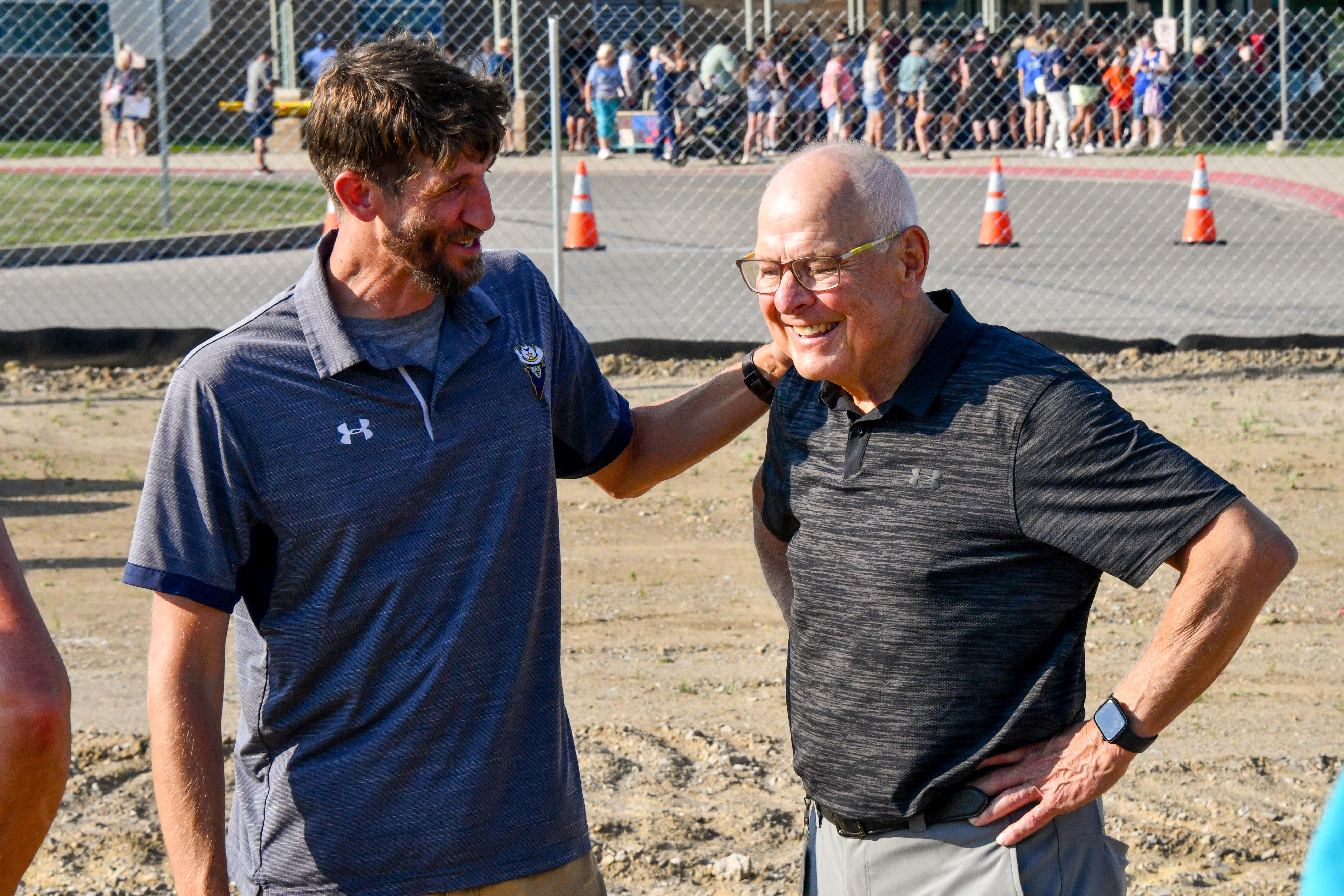 Two men standing in a dirt field