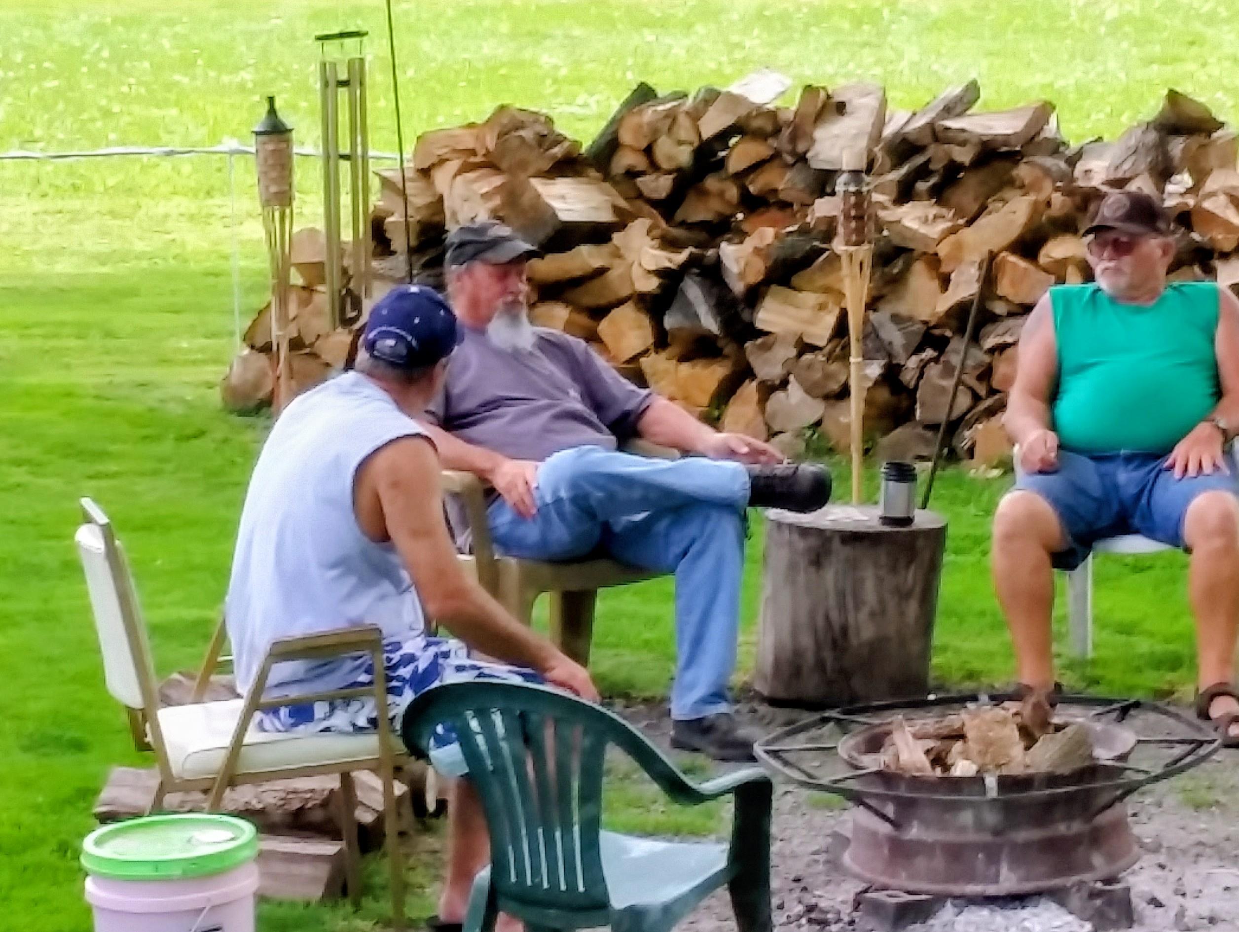 A group of people sitting around a fire pit