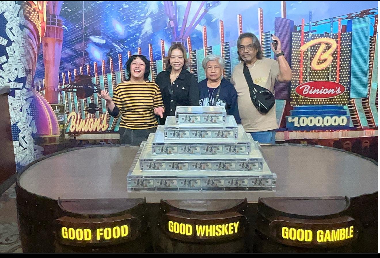 A group of people standing in front of a stack of money