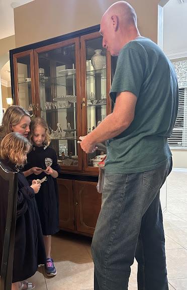 A man standing in front of a glass cabinet with a group of children