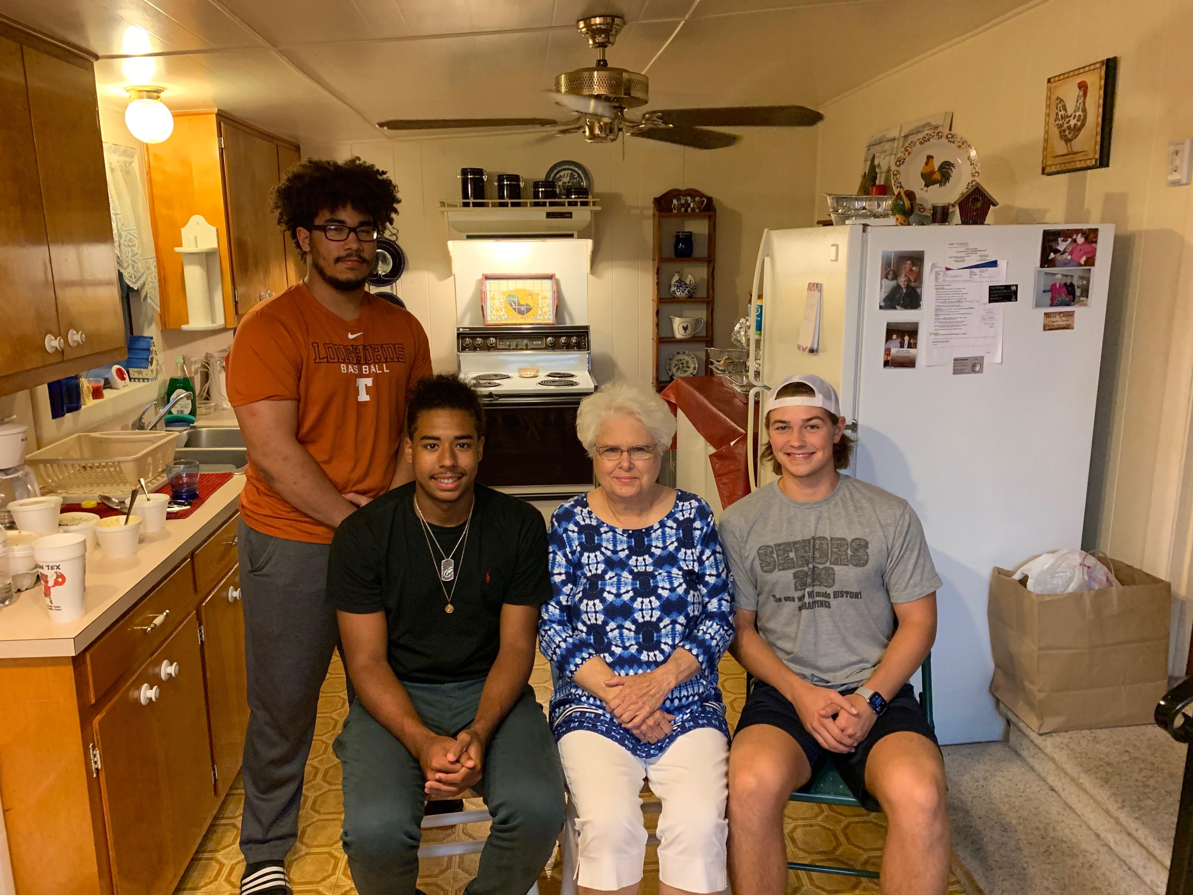 A group of people posing for a photo in a kitchen