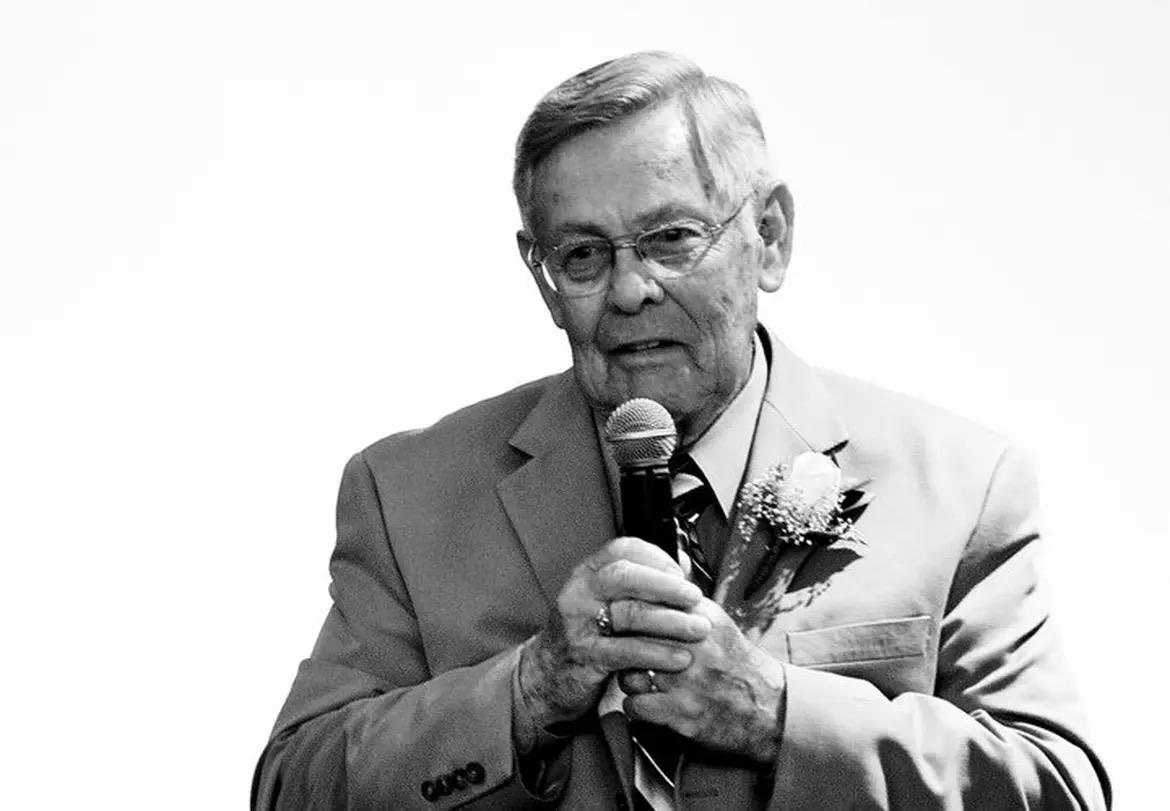 An old man holding a microphone