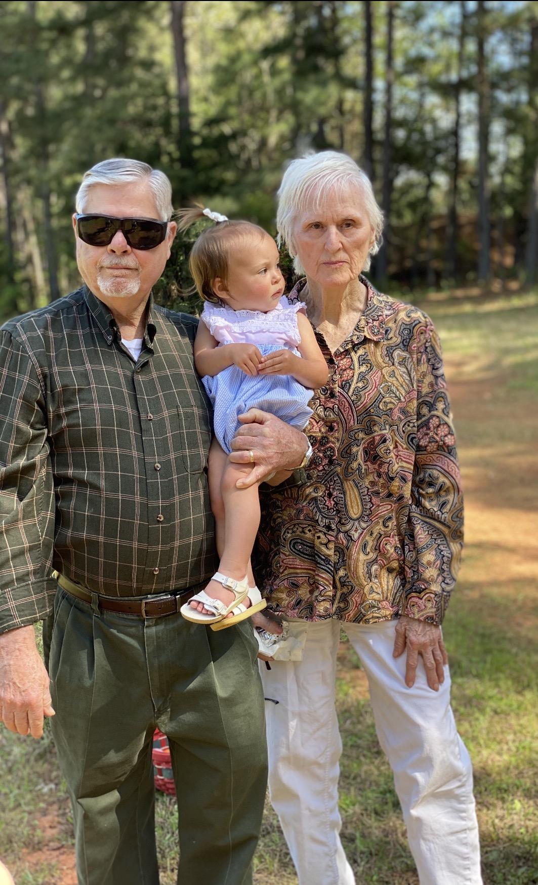 A man and woman holding a baby
