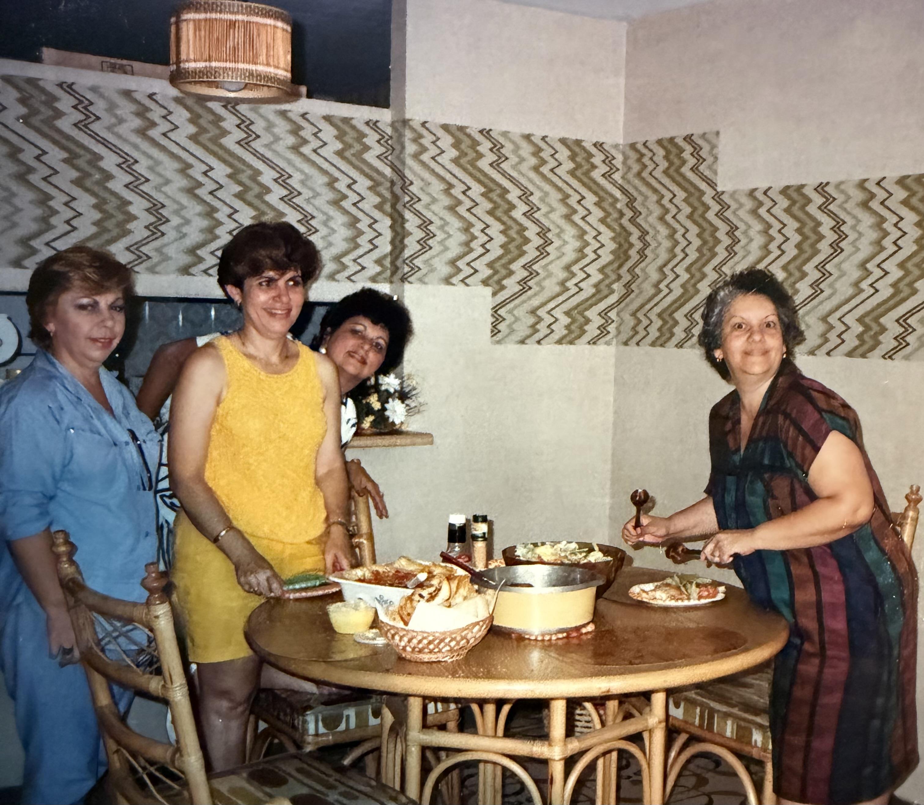 A group of women standing around a table
