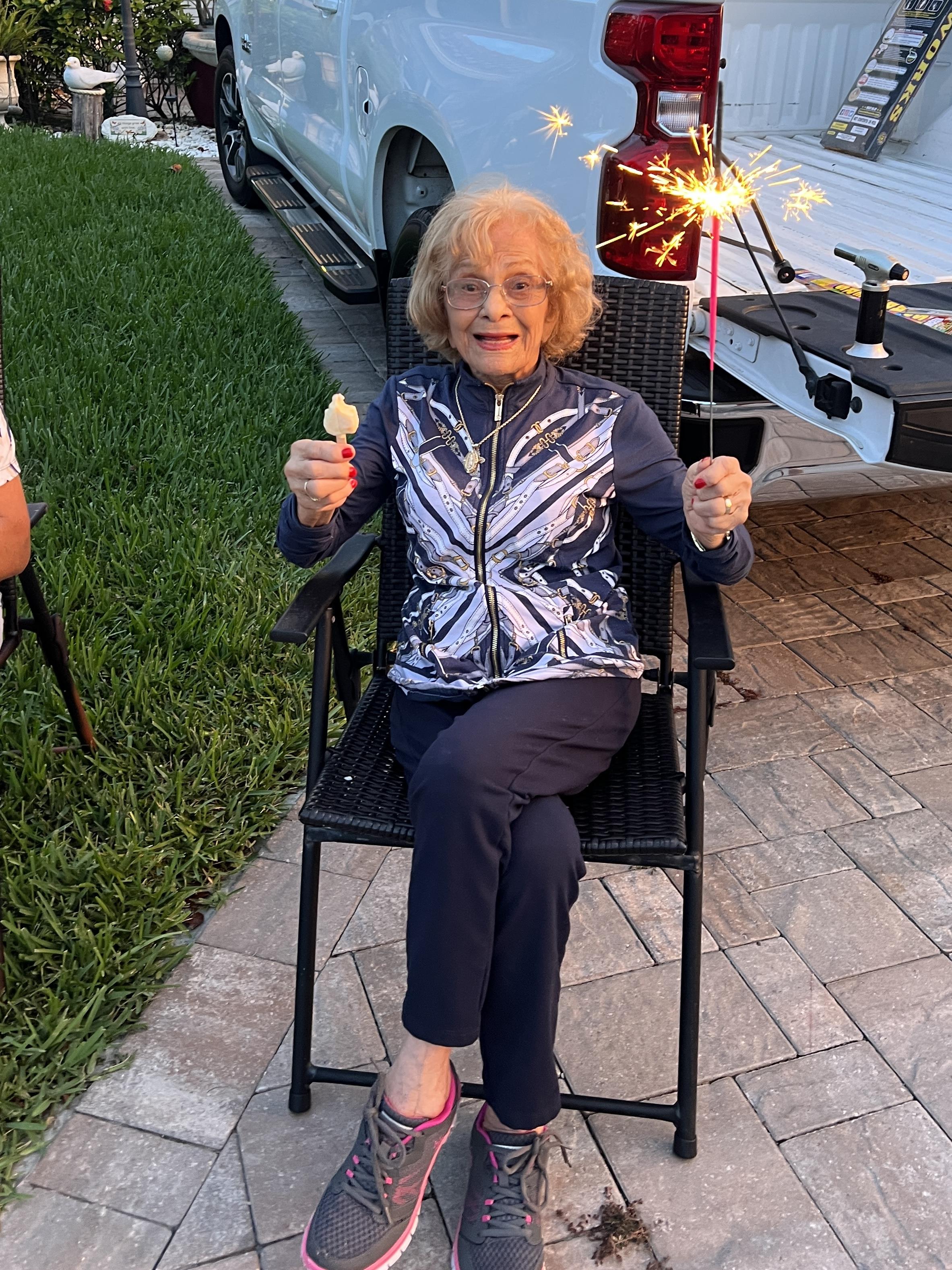 A woman sitting in a chair holding a sparkler